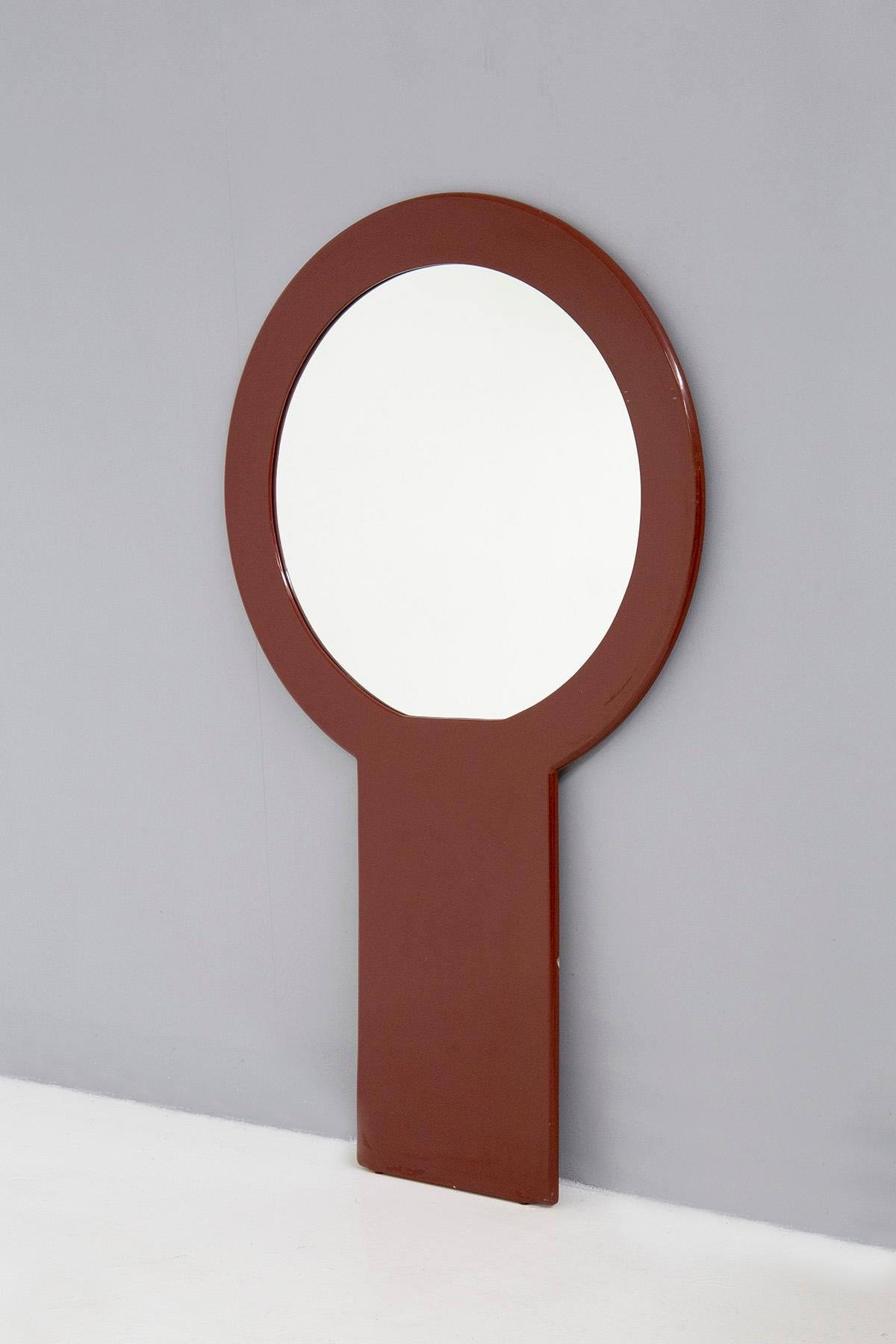 Eccentric and striking Italian wall mirror from the 1970s. Made by the Italian manufacture :FratelliI Sbrilli to Poggibonzi.
Label present in the back of the mirror. Made of brick red lacquered wood with circular mirror inside. Typically 1970s