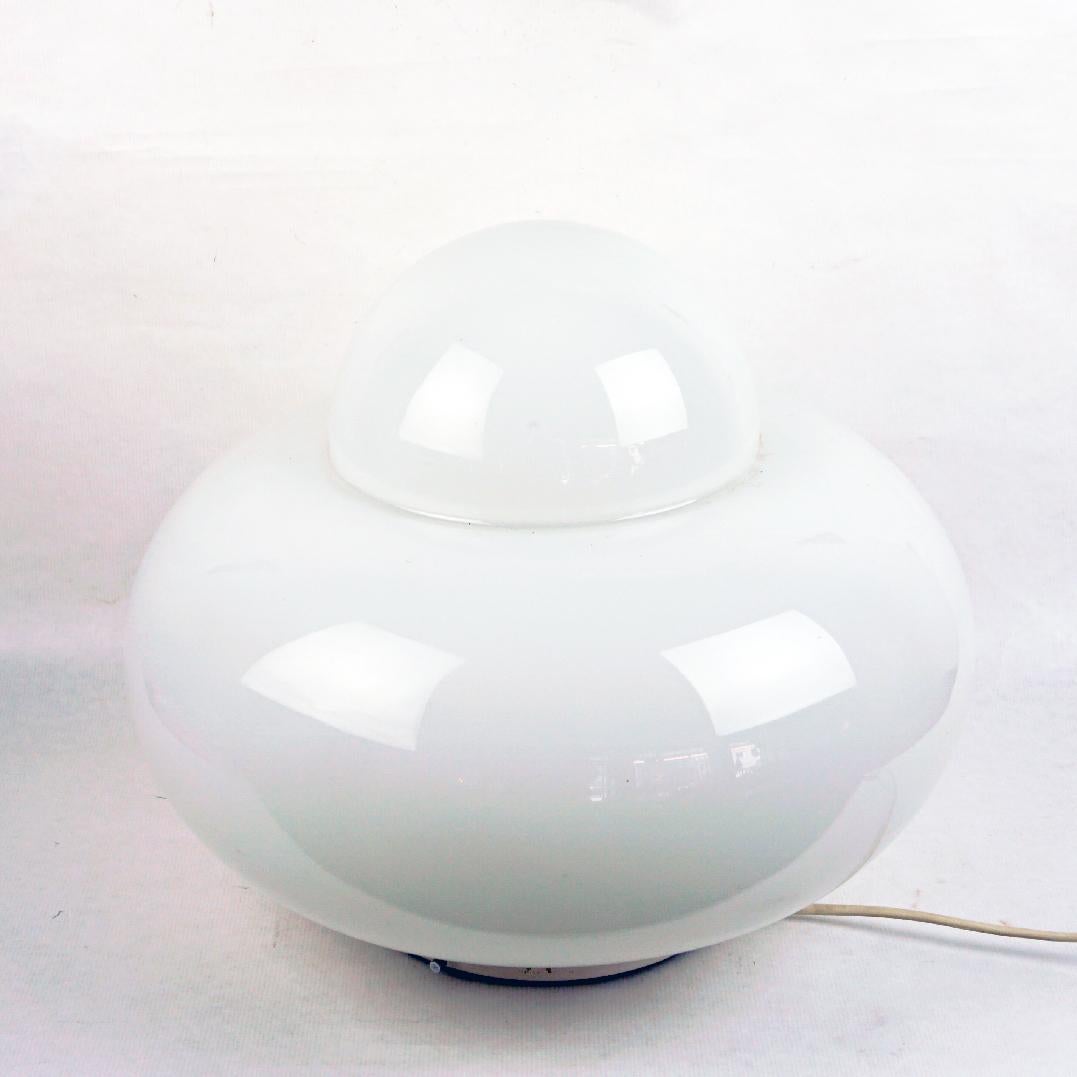 This Space Age White Opaline Glass Table lamp was designed and manufactured in Italy 1960s. Its Design is inspired by Sergio Astis Mod. Daruma Table Lamp or also by Giuliana Gramignas Electra Table Lamp for Artemide.
It features a white lacquered