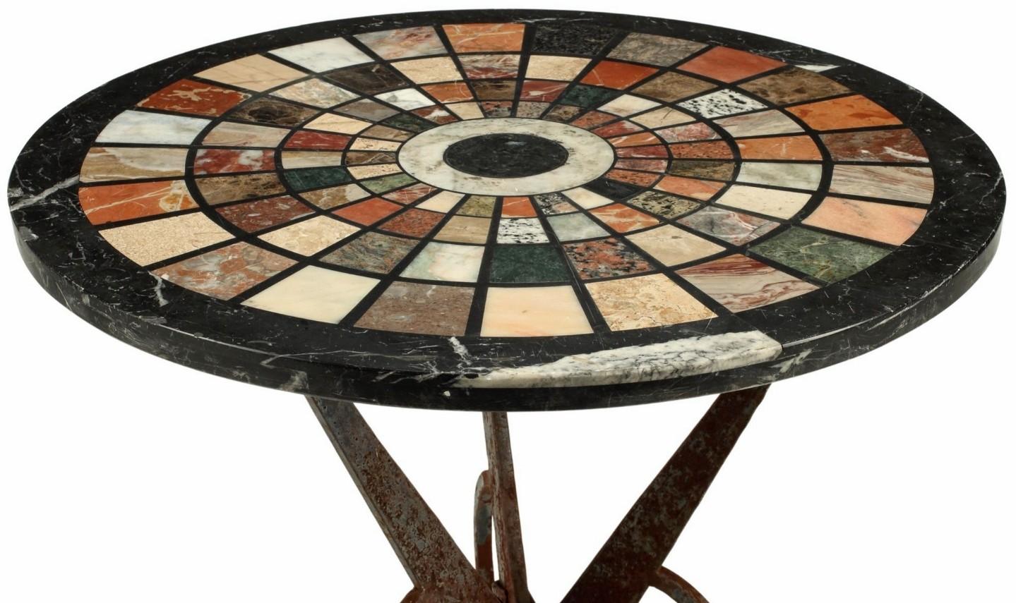 A visually striking wrought iron table topped with a magnificent 19th century Italian Grand Tour pietra dura style circular specimen top. Inlaid with 99 rare and exotic highly polished marble and precious hardstone samples arranged in a symmetrical
