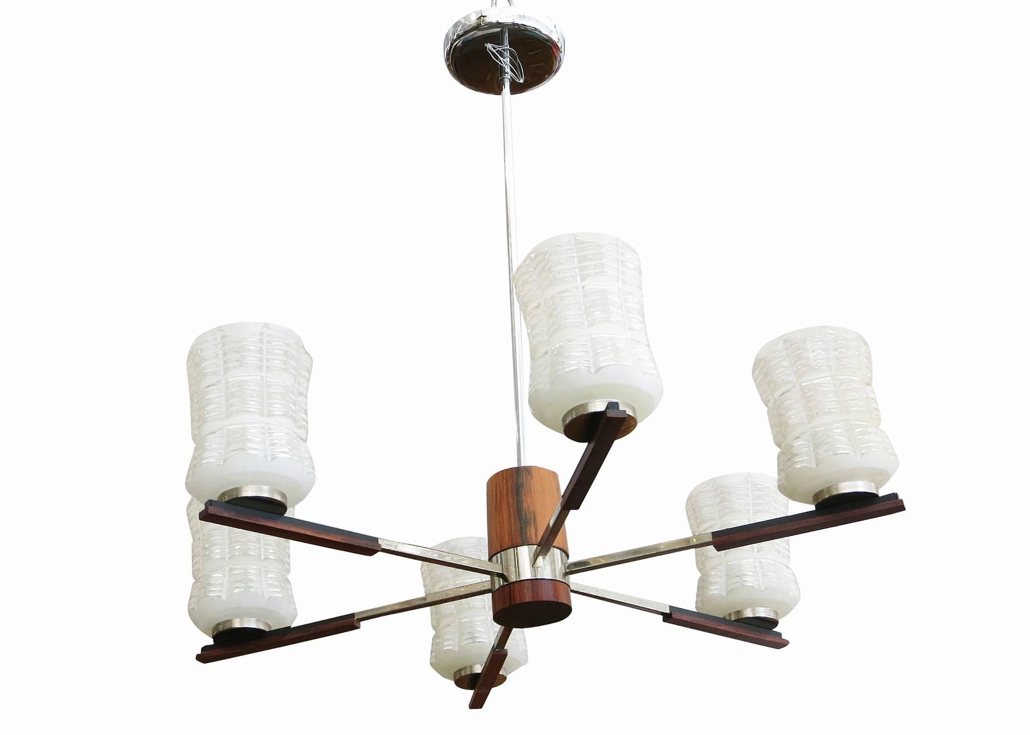 Italian Mid-century Sputnik chandelier with chrome arms and rosewood accents, circa 1960. Each arm holds a frosted glass shade textured with clear cut-outs.