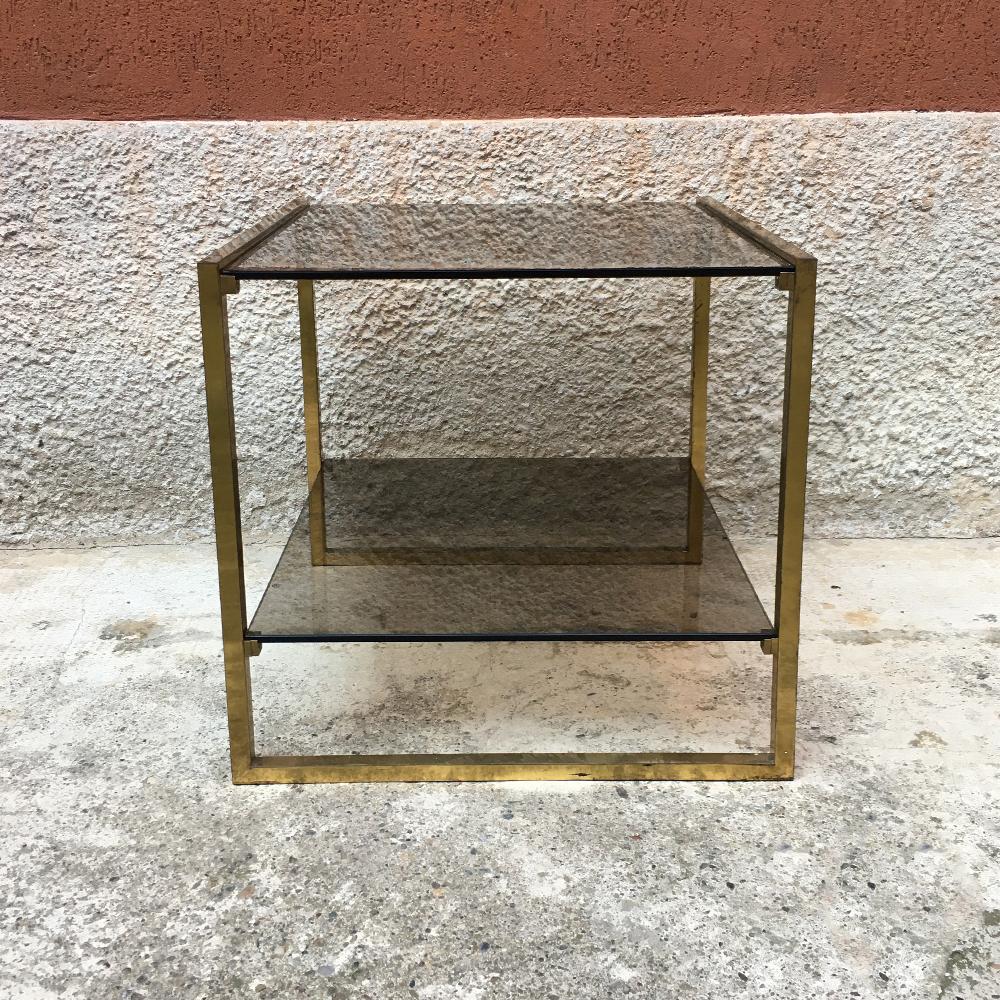 Italian square brass and double smoked glass shelf coffee table, 1970s
Brass coffee table with square section structure and double smoked glass shelf.
There are some defects in the corners of the shelves, but good general conditions.
Measures: 50