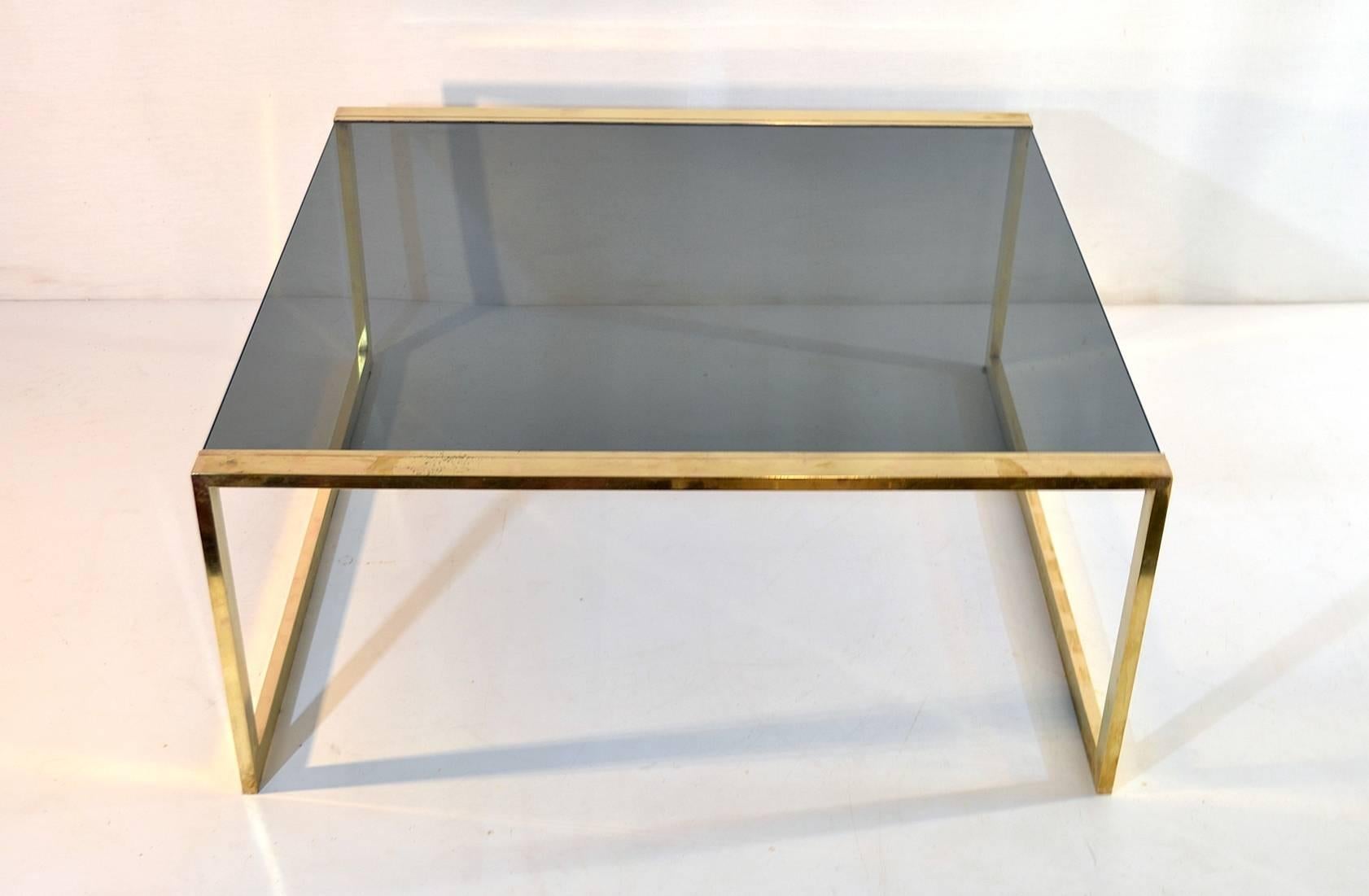 Coffee table with a clean cut design in brass with a smoked glass top in very good condition.
