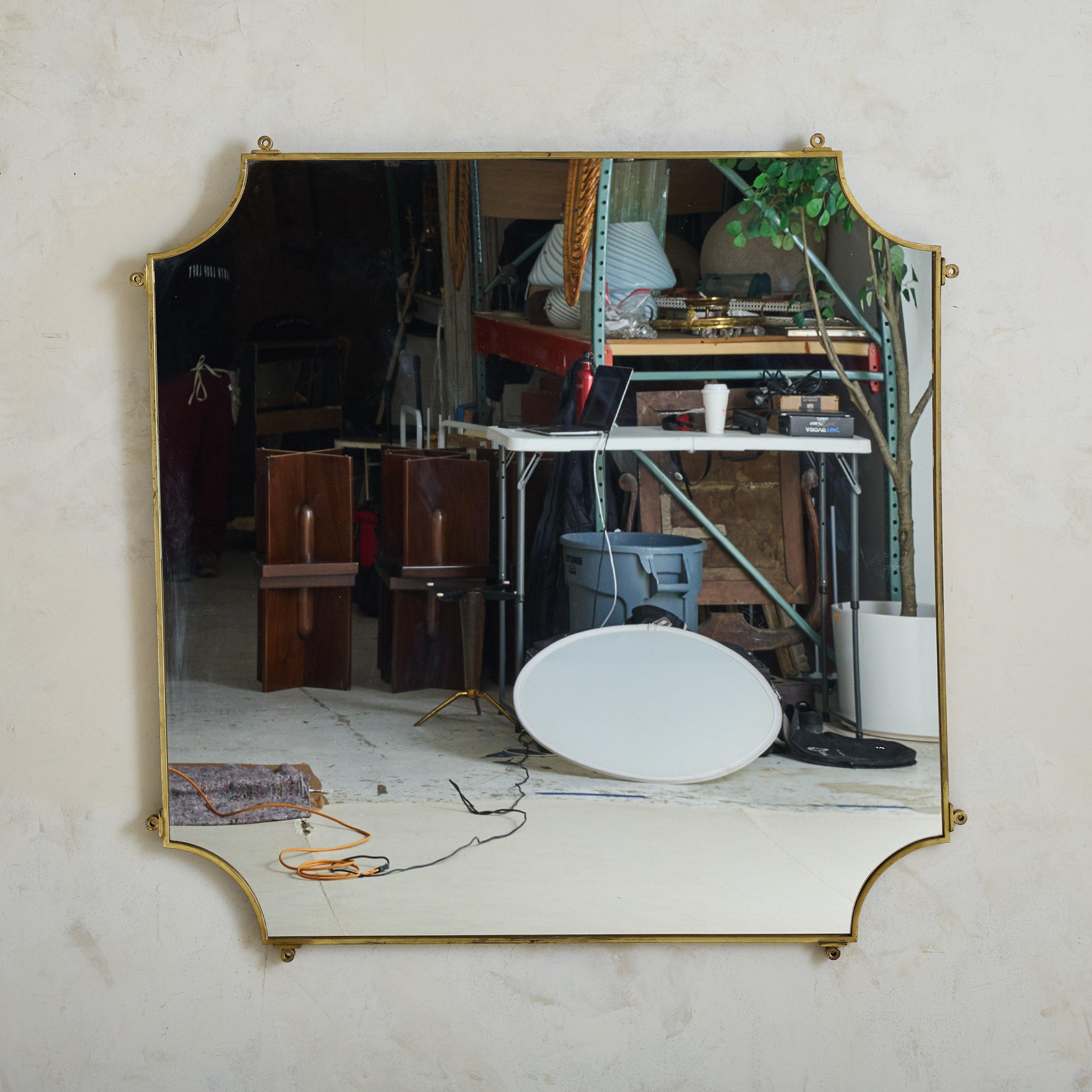 Sold and priced individually.

A 1960s Italian wall mirror with a square form, subtly softened by elegant scalloped corners. The delicate brass frame showcases a beautiful aged patina, adding warmth and character. Hanging hardware present on the