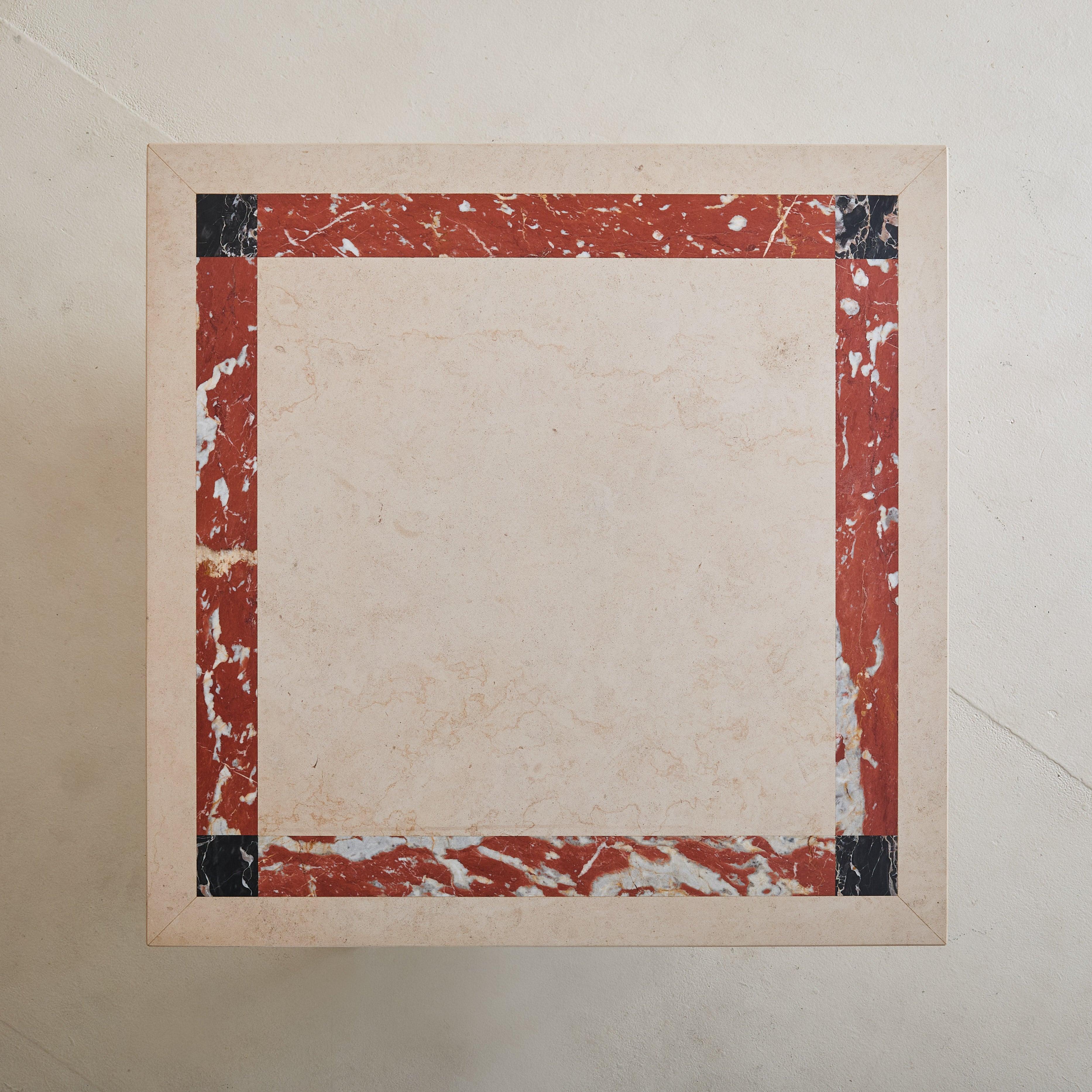 A refined expression of 1980s Italian design, this square coffee table features a striking marble top with bold geometric detailing in shades of ivory, red, and black. The natural marble surface is supported by four sturdy, cylindrical brass legs,