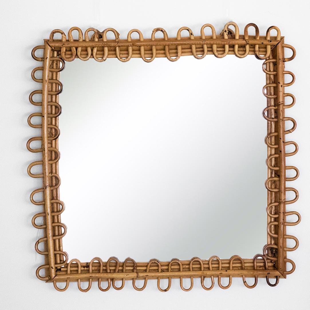 Italian square rattan mirror with looping rattan detail encompassing the mirror. Nice vintage condition with original mirror showing age and patina.