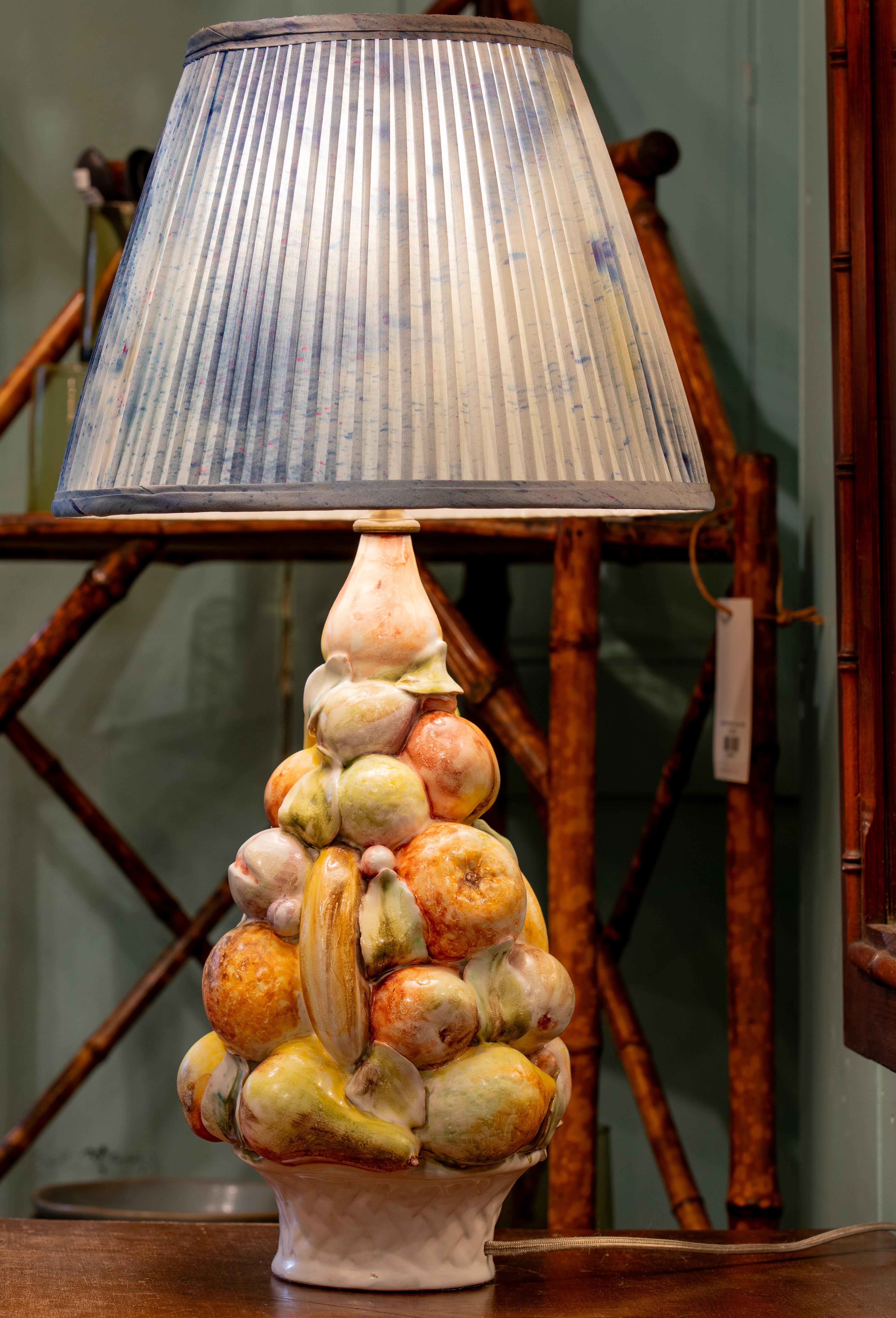 Charming hand-painted stacked fruit or fruit topiary table lamp. This lamp has beautiful soft colors and sits in a classic white pottery basket that is typical of this Italian style. It is difficult to find this sort of craftsmanship since many of