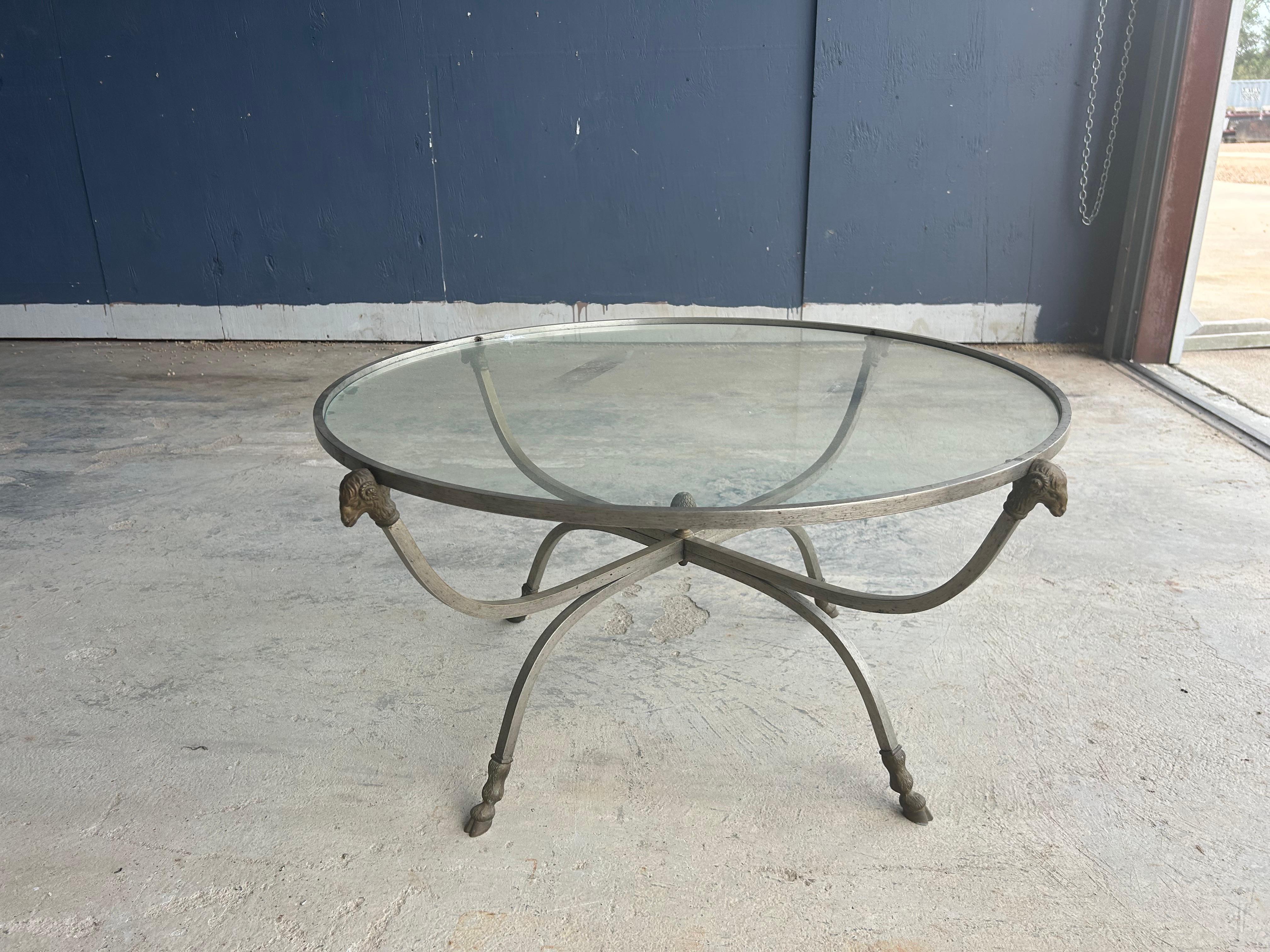 Italian Stainless Steel And Brass Coffee Table.
Offered is a beautiful Italian Maison Jansen style stainless steel cocktail table with brass ram's heads and hoof feet with a glass top.
This versatile Hollywood Regency or Neoclassical style coffee