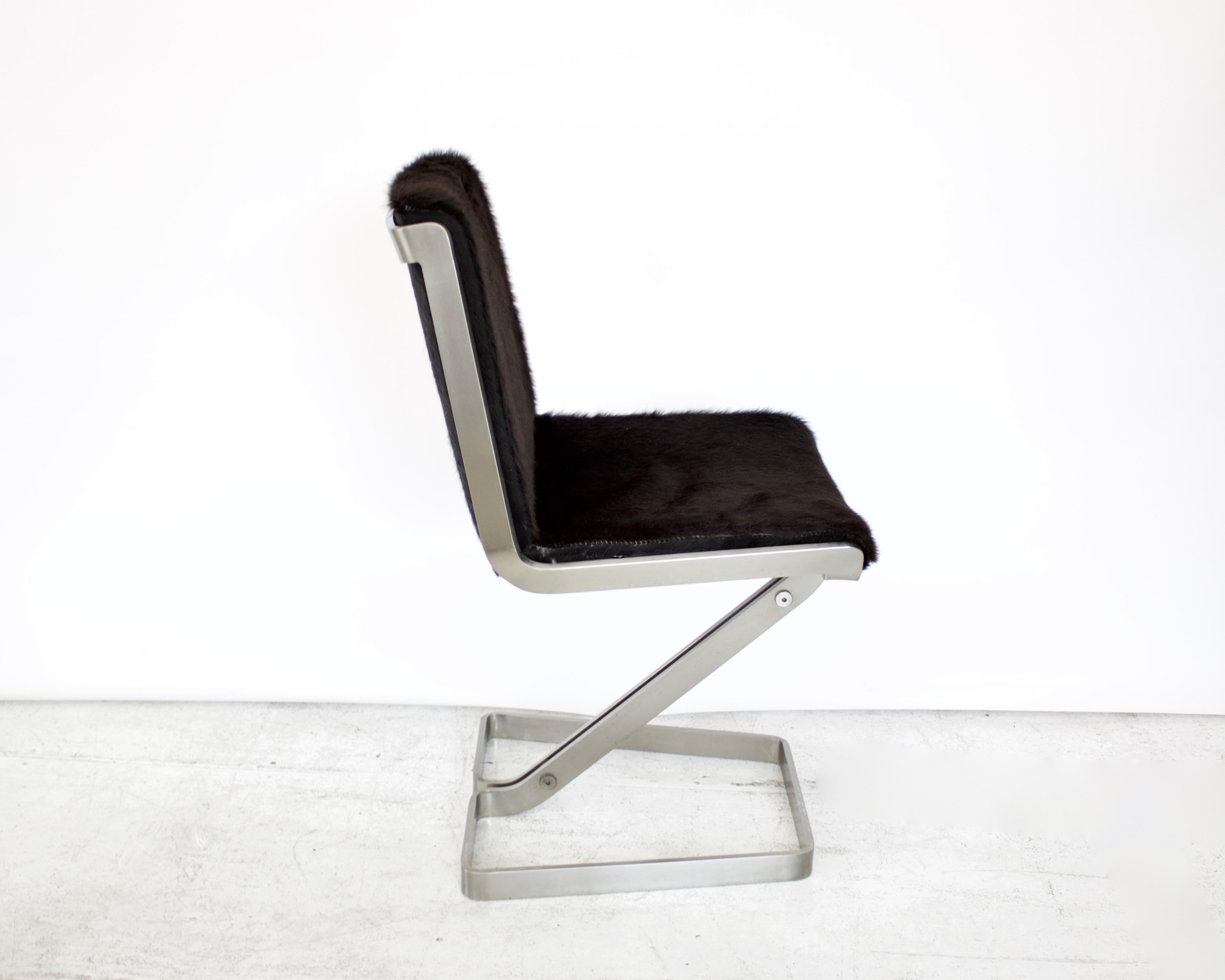 Stainless steel desk chair by Forma Nova and newly reupholstered in black hair on hide cowhide. The stainless steel is polished with a matte surface with no pitting or surface issues. The frame of the chair if very heavy and substantial.
The chair