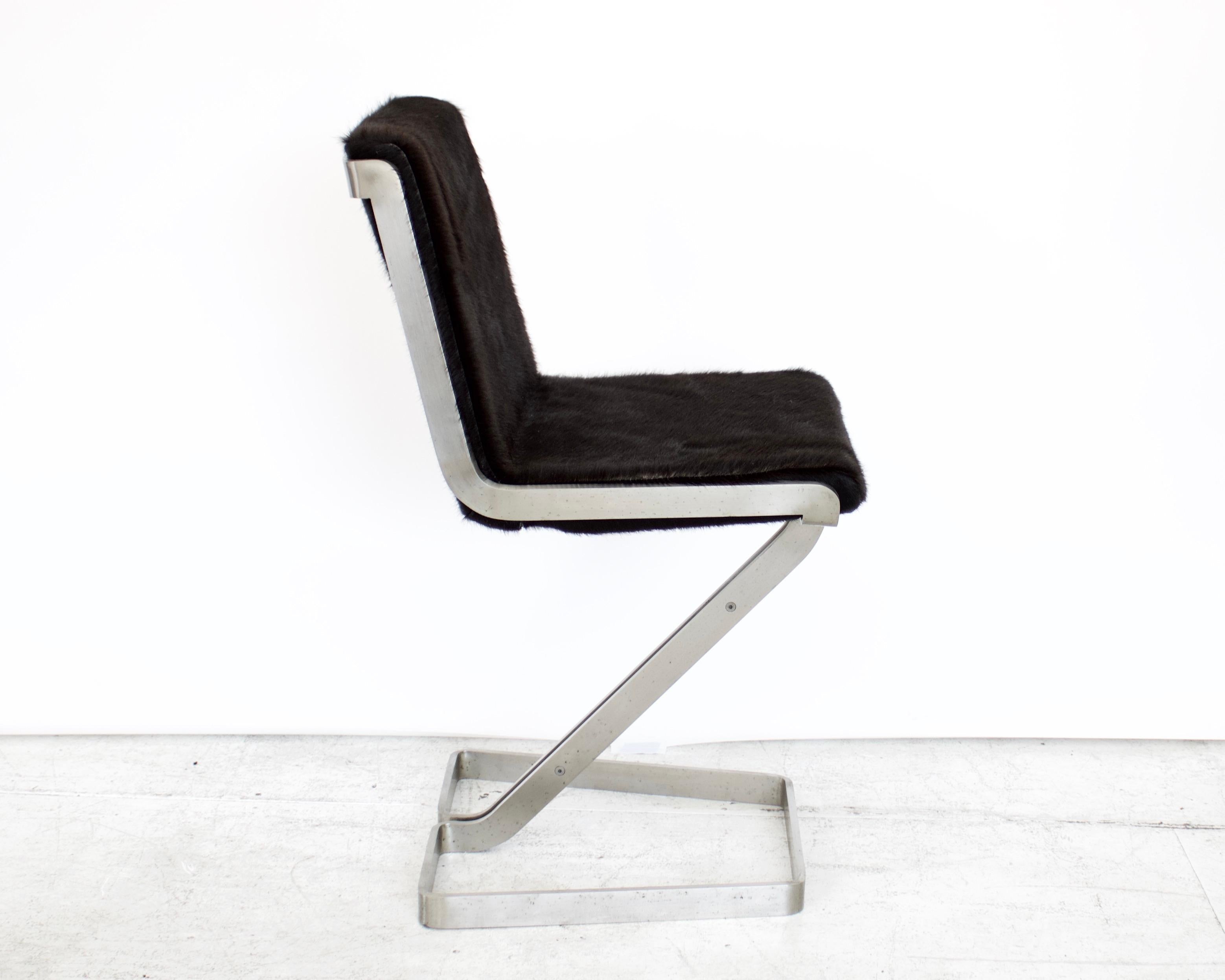 Stainless steel desk chair by forma Nova and newly reupholstered in black hair on hide cowhide. The stainless steel is polished with a matte surface with no pitting or surface issues. The frame of the chair if very heavy and substantial.
The chair