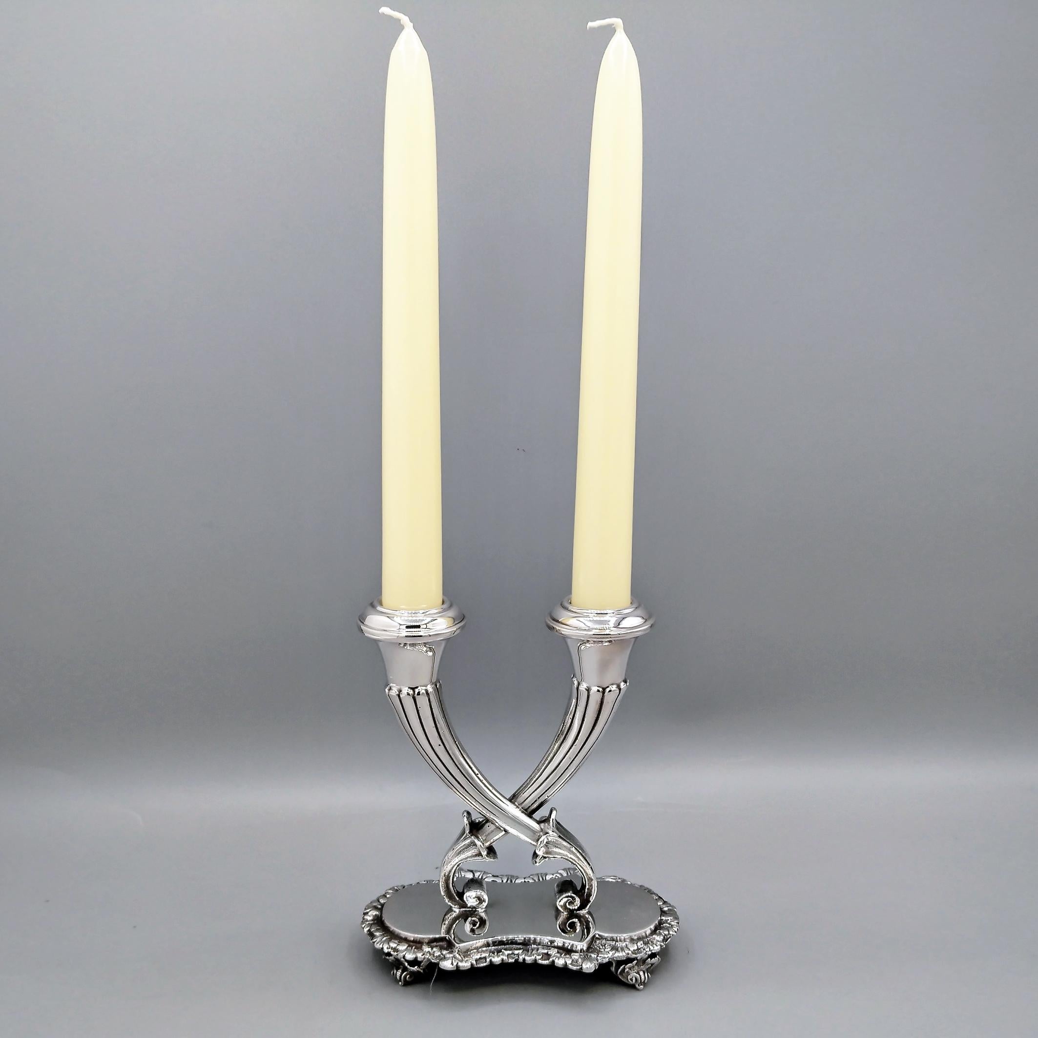 Un encantador candelabro con forma de dos cornucopias entrelazadas.
La base es de chapa de estilo catedralicio, a la que se ha soldado un borde de hojas.
La base se eleva de la superficie mediante cuatro pies en forma de concha.
En la base se han