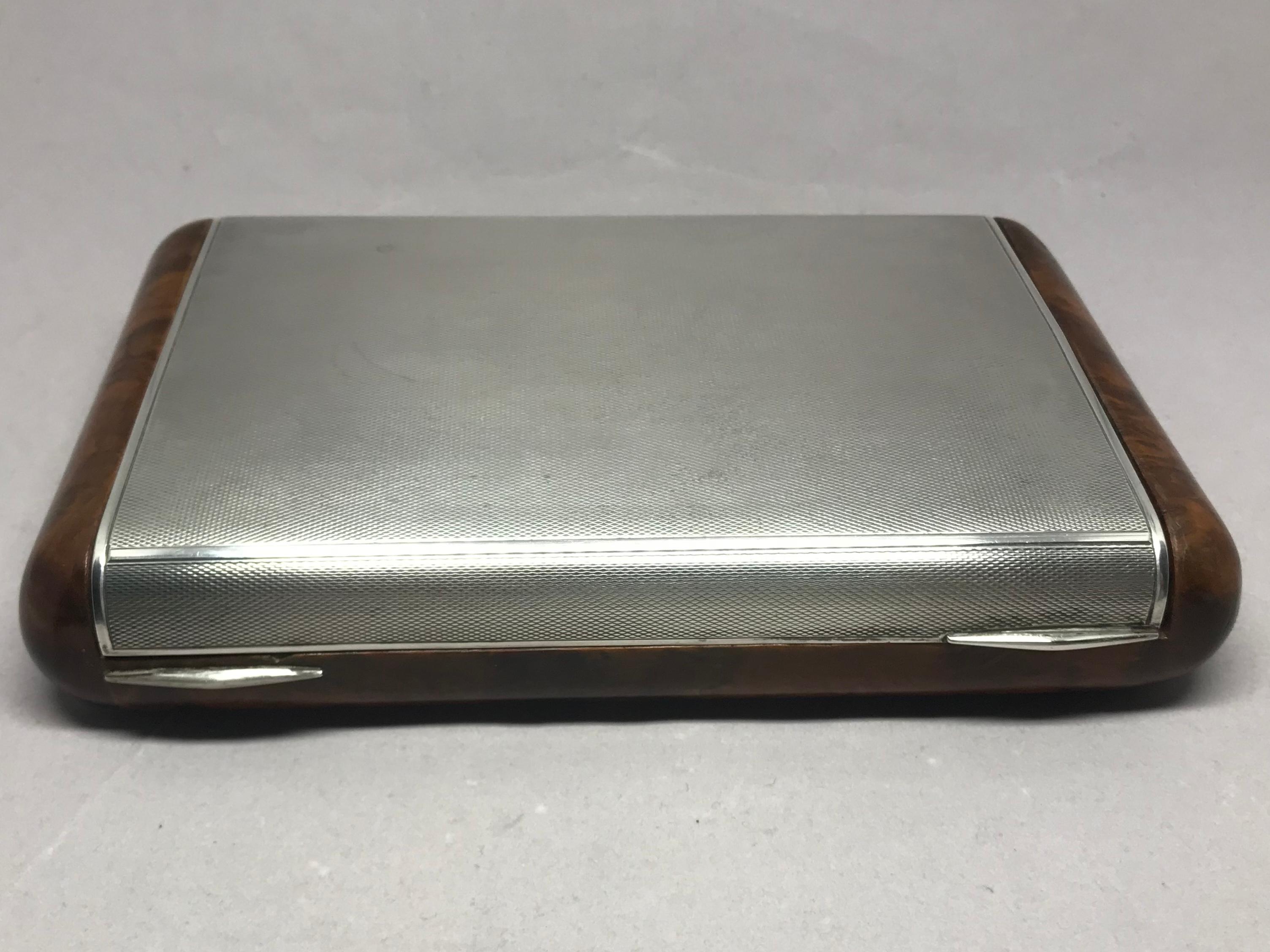 Italian sterling silver and burl wood box. Midcentury Italian silver hallmark burl wood hinged lidded box for cigarettes or vide-poche. Italy, circa 1940. 
Dimensions: 8” L x 5” D x 1.75” H.