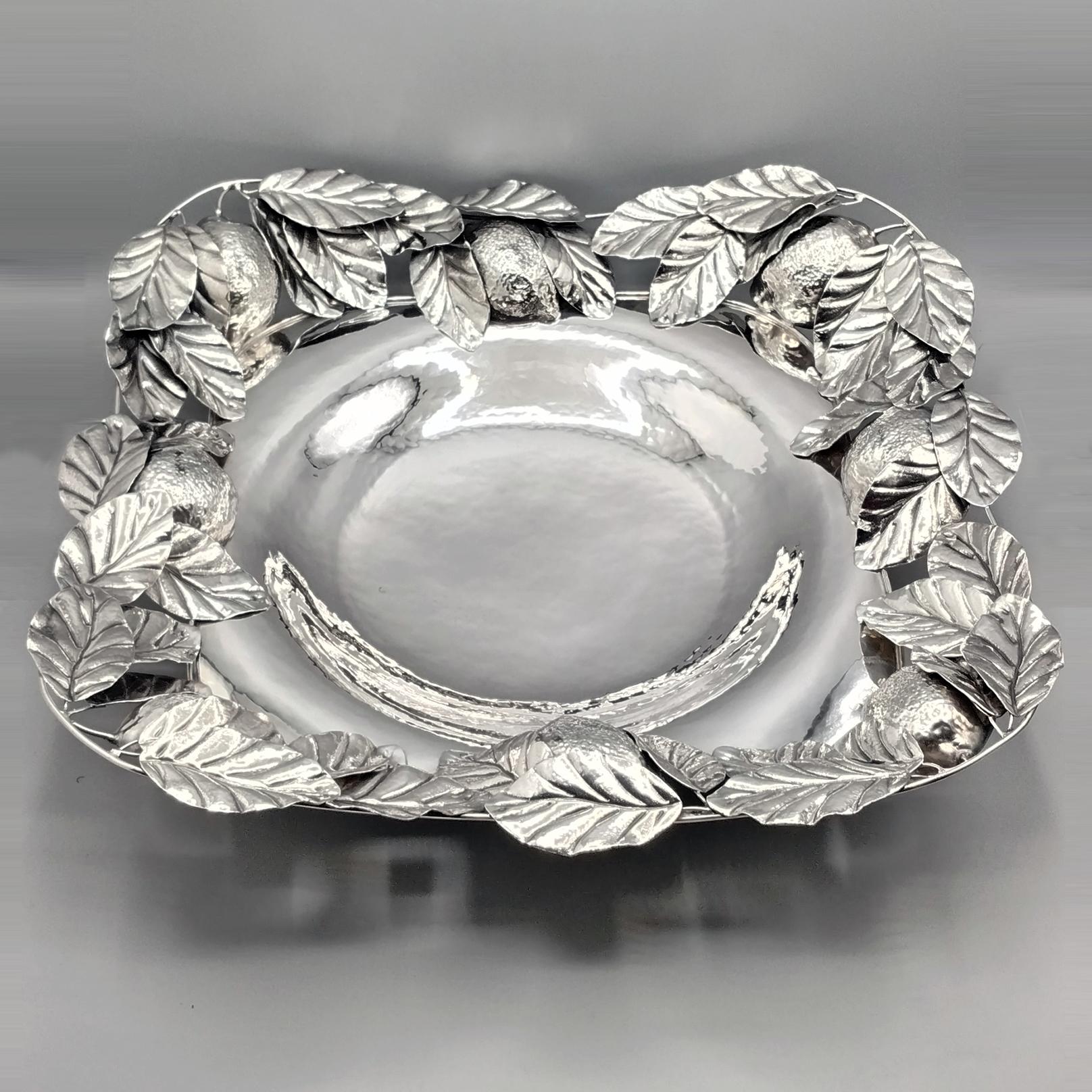 Silver centerpiece completely handmade.
The centerpiece was made starting from a sheet of 925 silver and modeled, shaped and hammered completely by hand,
On the edge of the centerpiece, lemons and chiseled lemon leaves were soldered giving the