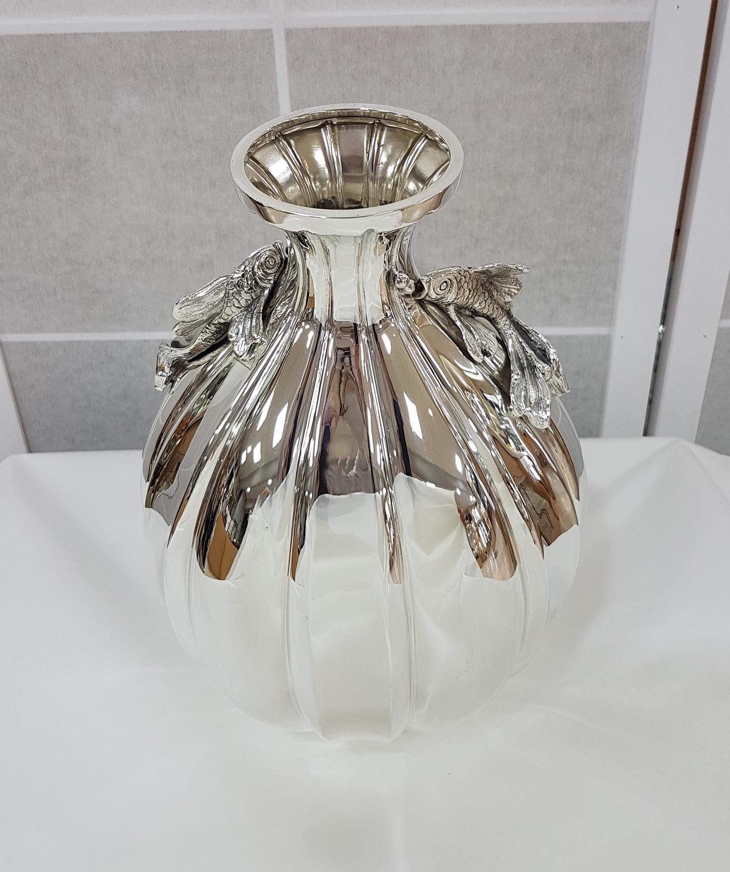 Beautiful vase in sterling silver completely handmade with chiseled strips.
The round body ends with the upper part which is narrow and decorated with 2 cast fish
1,020 grams.