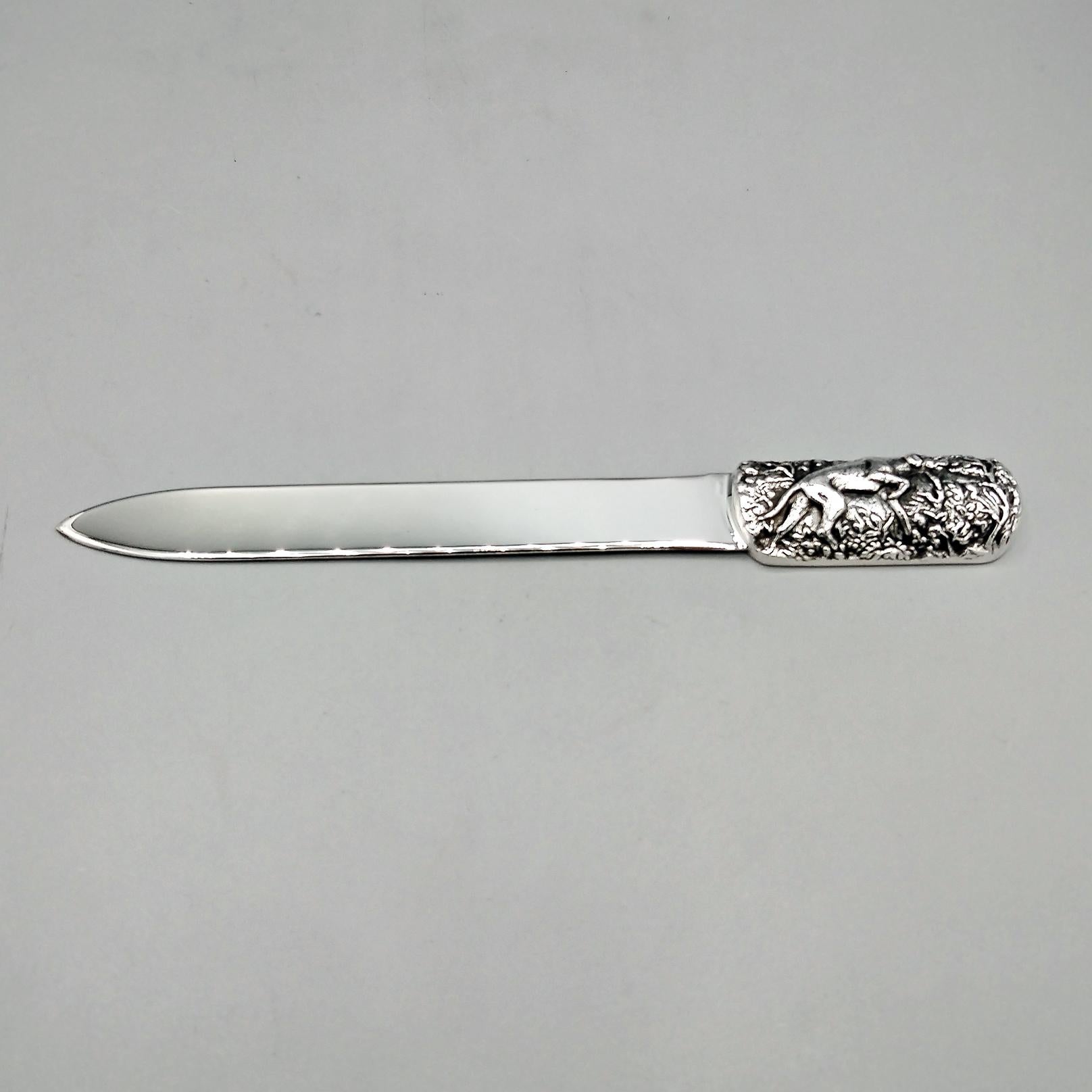 Brieföffner aus Sterlingsilber, handgeformt aus einer rohen Sterlingsilberplatte.
Der Griff, der einen von Blumen und Blättern umgebenen Jagdhund darstellt, wurde gegossen, ziseliert, gebogen und auf den breitesten Teil des Brieföffners gelötet.
Die