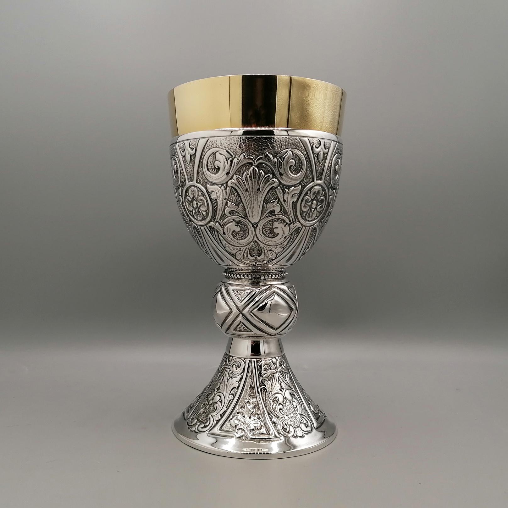 Liturgical chalice made of sterling silver. 
Chalice with a round and elegant shape, features an embossment over its entire surface
On the cup and base, embossing and chiseling with scroll design, typical of the Baroque style, have been