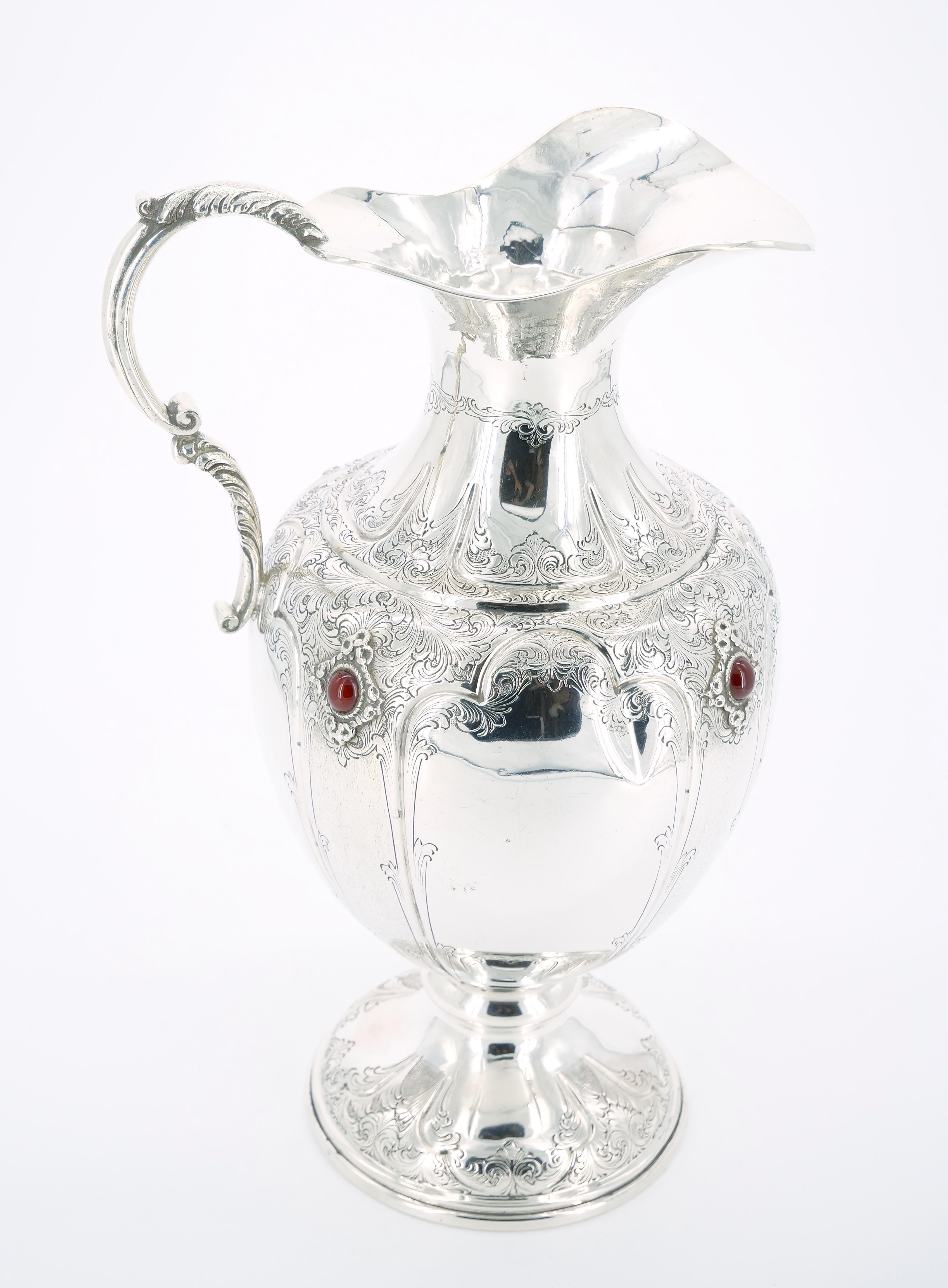 Voici un captivant vase décoratif à une anse en argent sterling et pierres précieuses du XIXe siècle, un véritable chef-d'œuvre d'artisanat et d'art. Cette pièce remarquable présente une forme de bouteille avec un col de pichet, avec une élégante