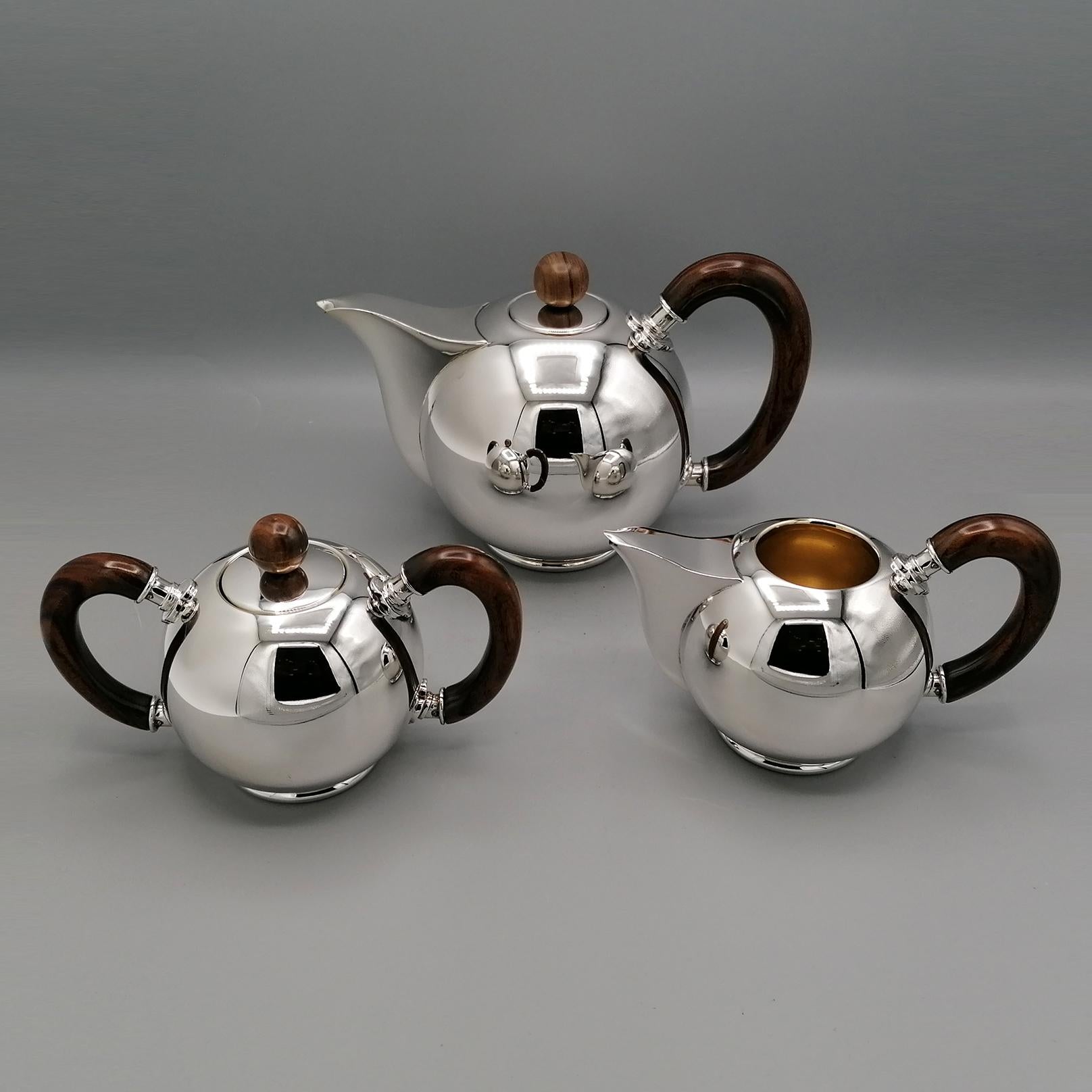 Completely handmade this Teaset is in sterling silver in a modern style with a spherical shape, shiny and essential shapes with handles and knobs in precious wood.
The teapot has a sterling silver lid with a wooden knob and a 