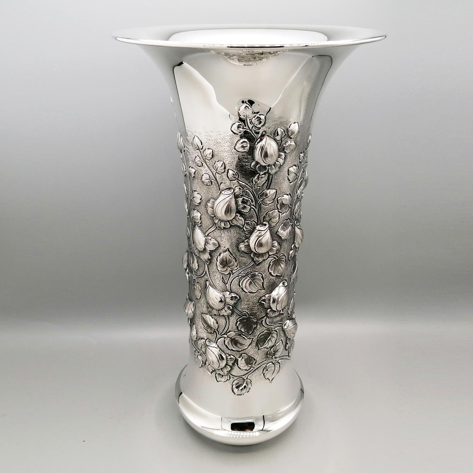 Jarrón de plata de ley con rosas y hojas.
El cuerpo del jarrón es cilíndrico y está repujado y cincelado con un diseño de rosaleda.
Entre las hojas, las ramas y los capullos se ha creado un moleteado para resaltar el repujado y el cincelado.
La