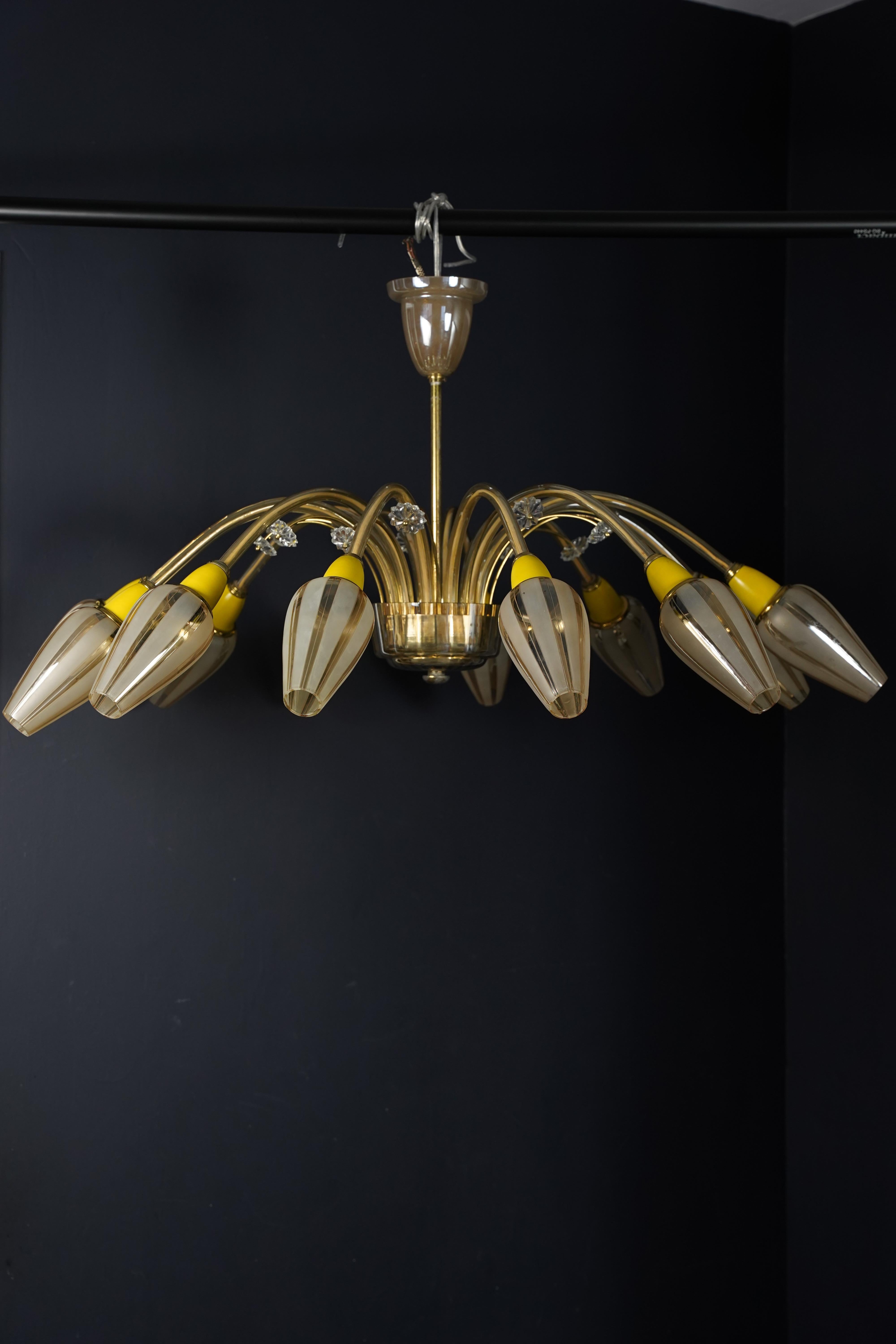 Struttura in ottone con 12 bracci, ciascuno con un paralume in vetro di Murano, Italia anni '50.
Telaio in vetro con 12 posti  prese a candelabro, baldacchino e fondo in vetro  12 bracci in ottone che sorreggono un piccolo fiore di vetro trasparente