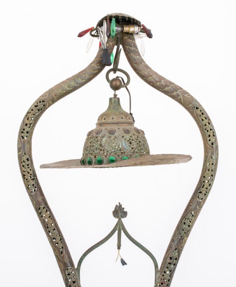 Middle Eastern reticulated brass floor lamp, the double-support form lamp with pendant glass gem-set and crystal hung shade above a circular base, overall pierced with scrolling foliate motifs.