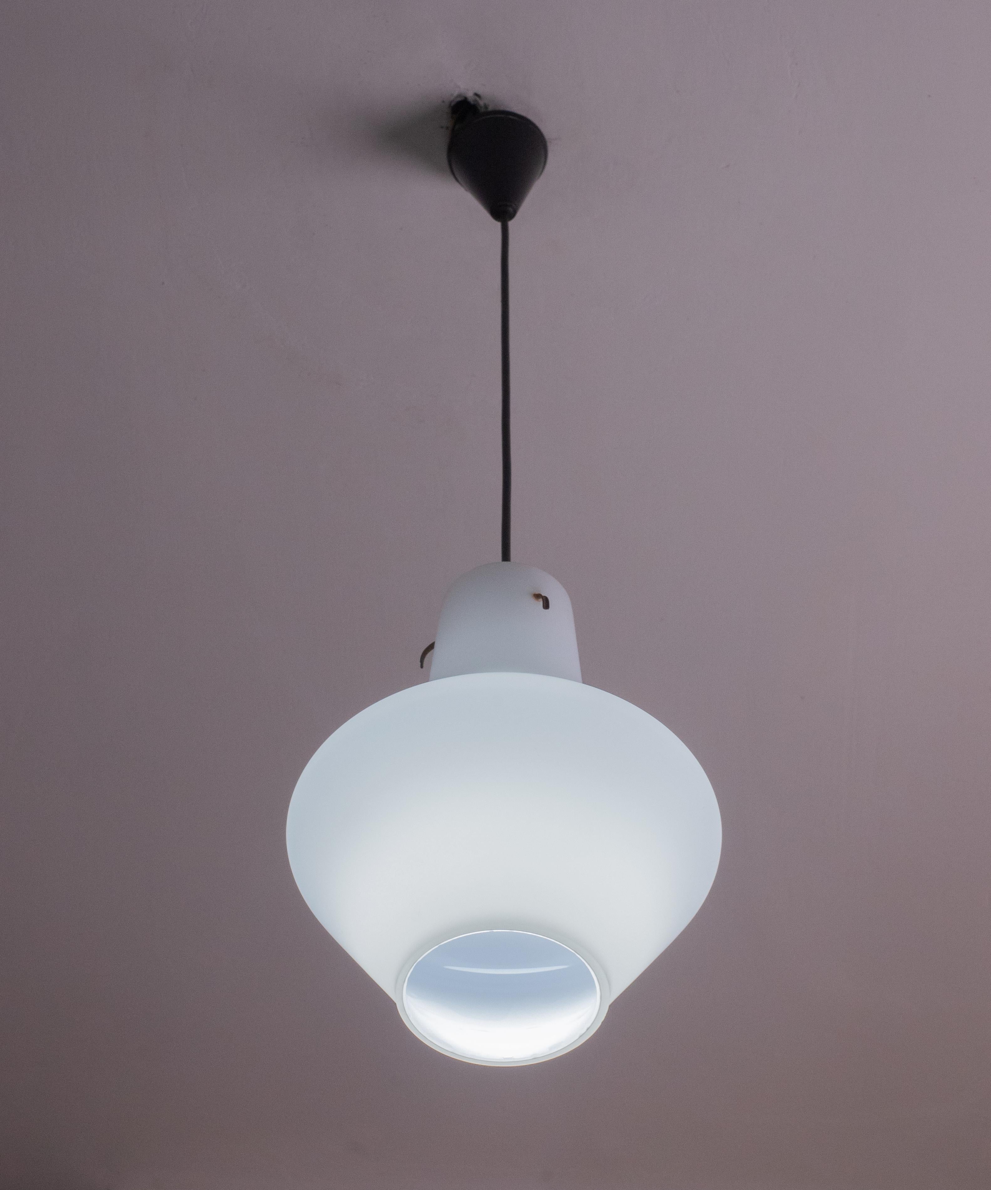 Stilnovo-designed opal glass pendant made in the 1970s.
The canopy is made of white opal glass. The pendant is ideal for decorating vintage industrial spaces and above a prominent table or kitchen island.
The lamp mounts a standard European e27