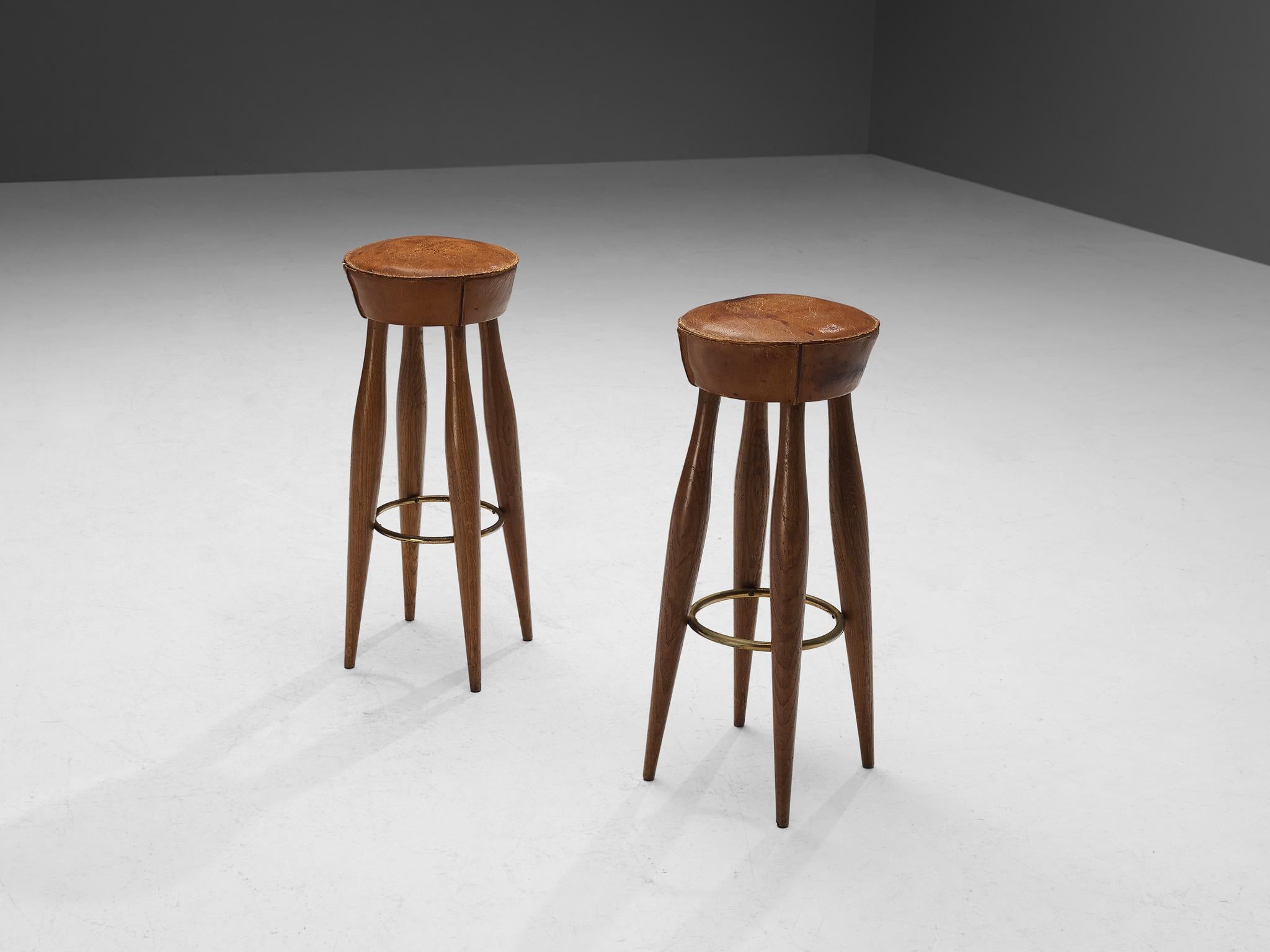Pair of stools, oak, patinated leather, brass, Italy, 1950s

Charming and charismatic pair of stools made in Italy in the 1950s. These stools show elegant detailing, like the outward stitching of the leather seats, and the brass circle in between