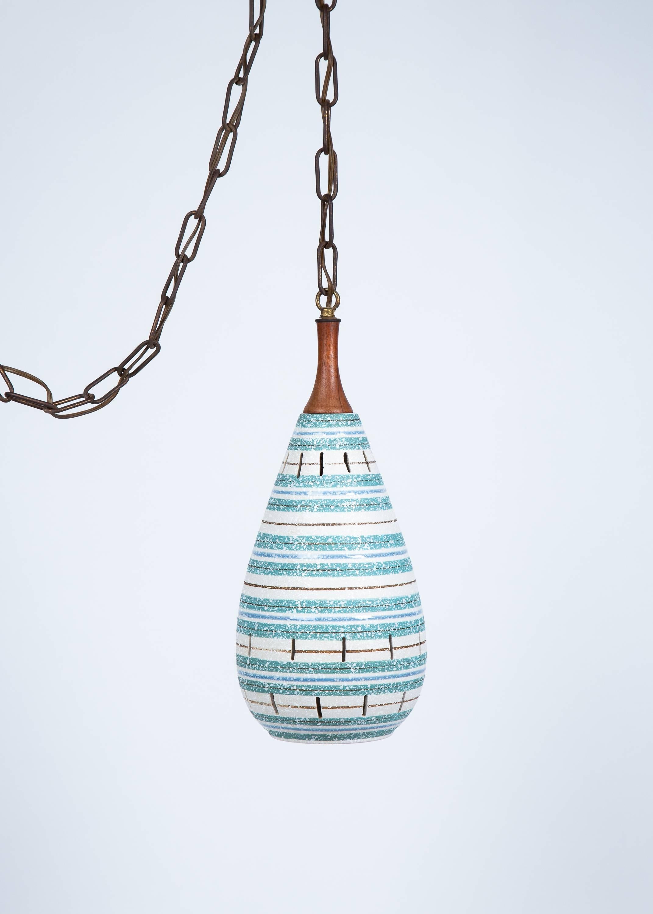 Italian turquoise and white stripe ceramic hanging pendant chandelier has textured glaze and walnut stem. Light illuminates through elongated openings in ceramic body.
 Lamp body measures 17