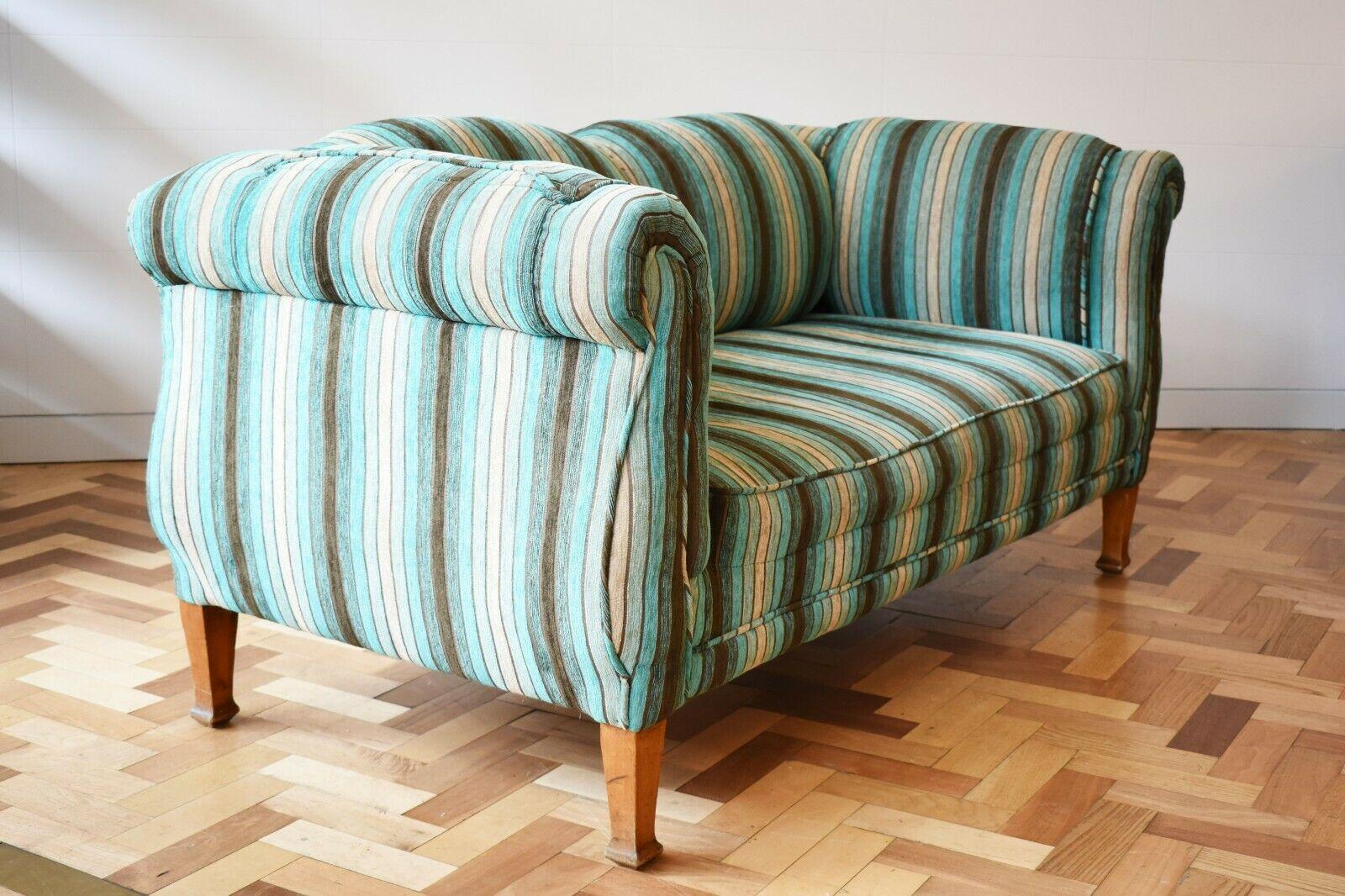 This early 20th century Italian striped two seater sofa features interesting curved shapes throughout that accentuate the beauty of the high quality cotton velvet blue, green and grey coloured fabric. Set on wooden legs, this is a beautiful and