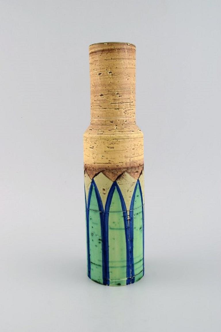 Italian studio ceramicist. Cylindrical vase in glazed stoneware. 
Hand-painted green leaves on yellow background. 1960s / 70s.
Measures: 30.5 x 8 cm.
In excellent condition.
Signed.