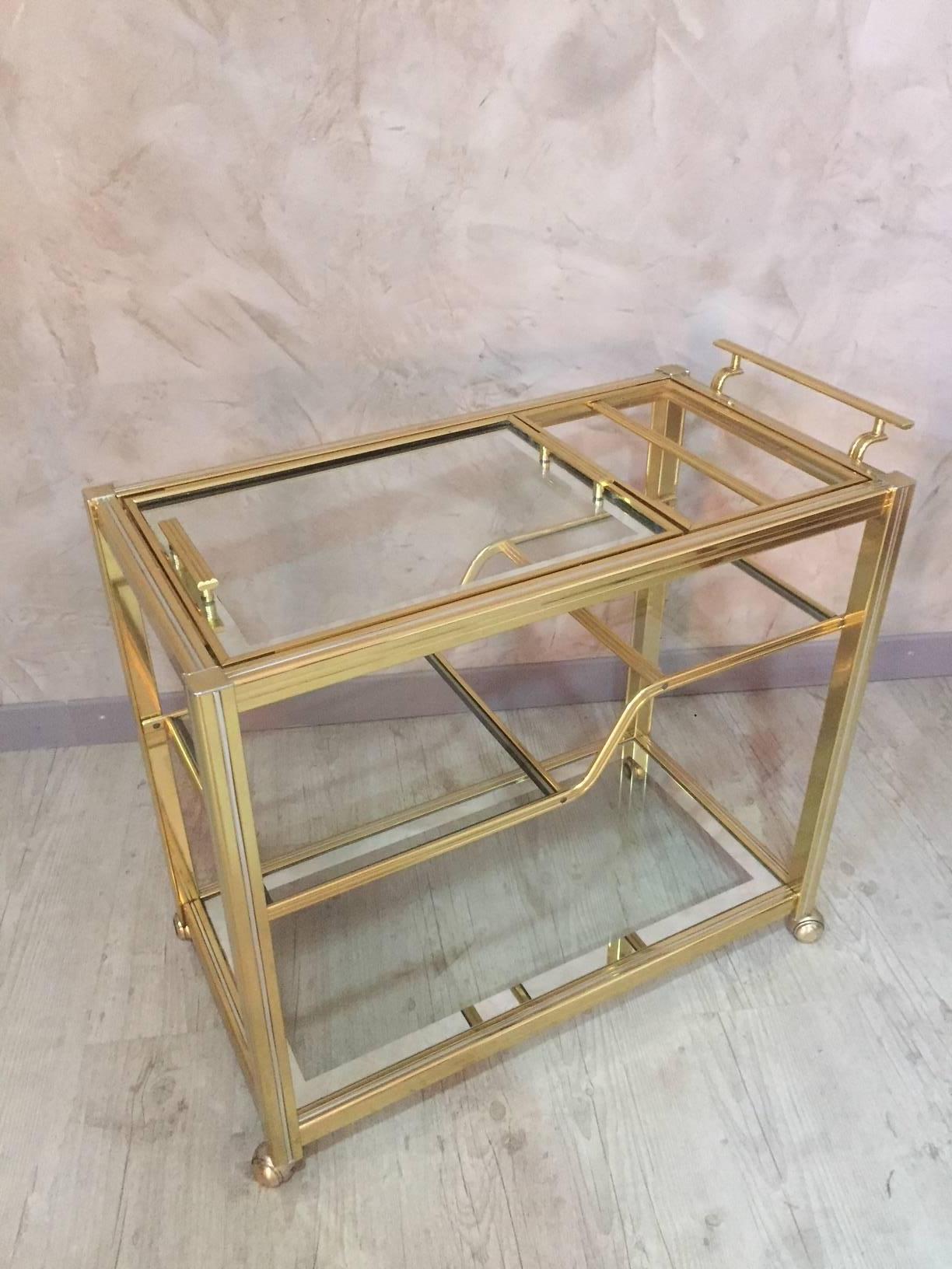 Italian style gilded brass and glass rolling dessert table from the 1970s. Italian style called Romeo.
The tray on the top is removable with the two handles.