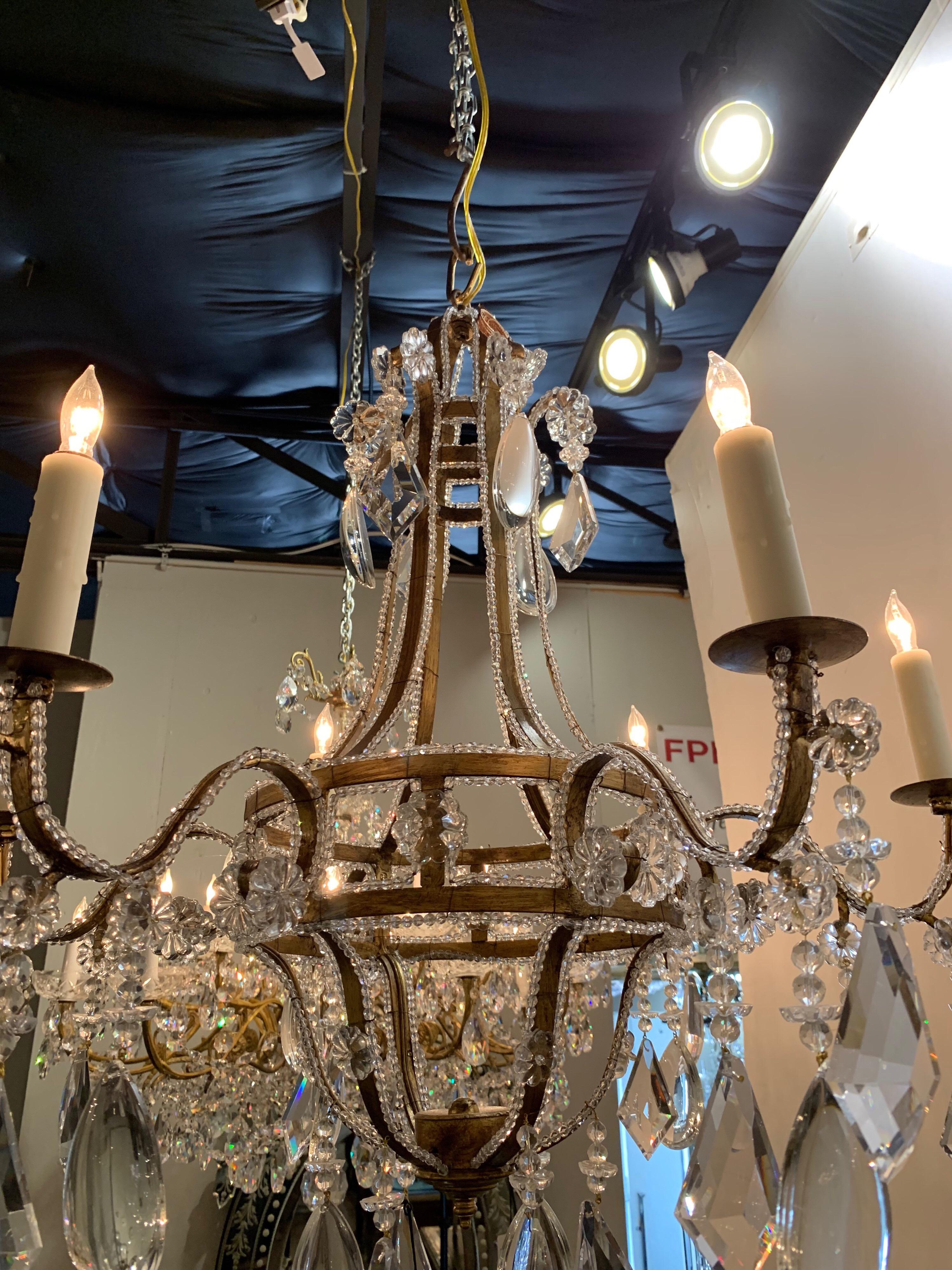 Beautiful Italian style gilt metal beaded crystal chandelier with 6 lights. Lovely beaded details along the base and an abundance of dangling prisms. Comes with a decorative chain and canopy, ready to hang.
 