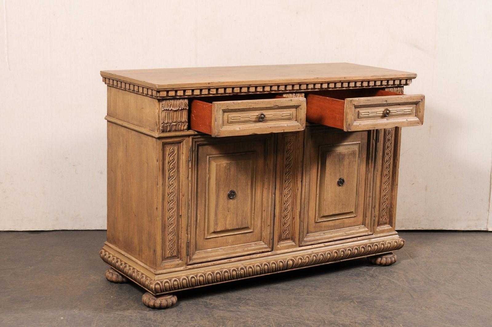 Ein italienisch inspirierter, in Amerika hergestellter Buffetschrank aus geschnitztem Holz. Dieser Vintage-Schrank wurde mit italienischen Einflüssen entworfen und hat eine rechteckige Platte mit einer dick geschnitzten Zackenleiste an der