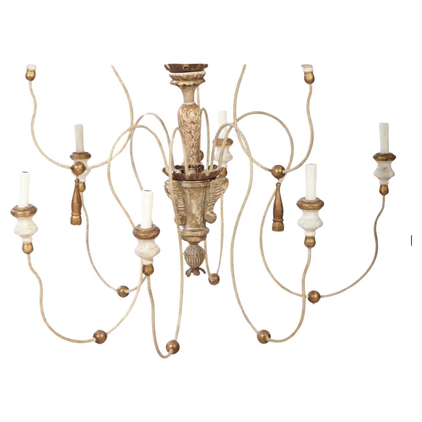 Très grand lustre à neuf lumières en bois peint, doré et en fer de style italien.  Le lustre se compose d'un support en bois sculpté et doré, de six fils de fer courbés suspendus à de grandes houppes en bois doré et de neuf bras en fil de fer,