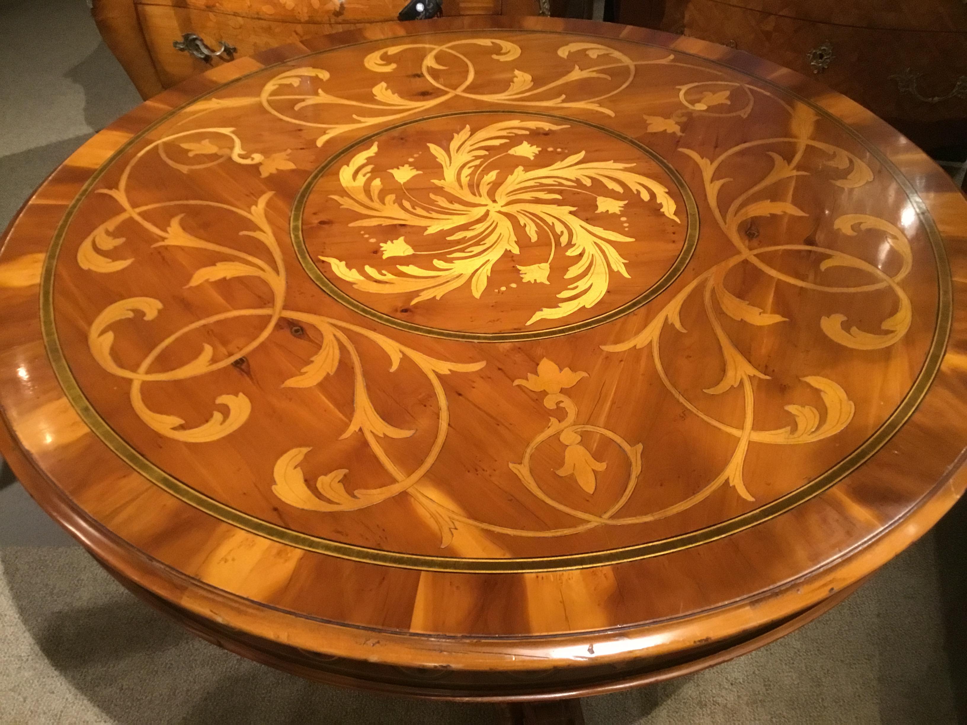 Round center table with fine inlays of satinwood executed in trailing vines
Motif. Additional inlays surround the apron. The shaped pedestal base
Has carved scrolls and ruffles with gadrooned trim.