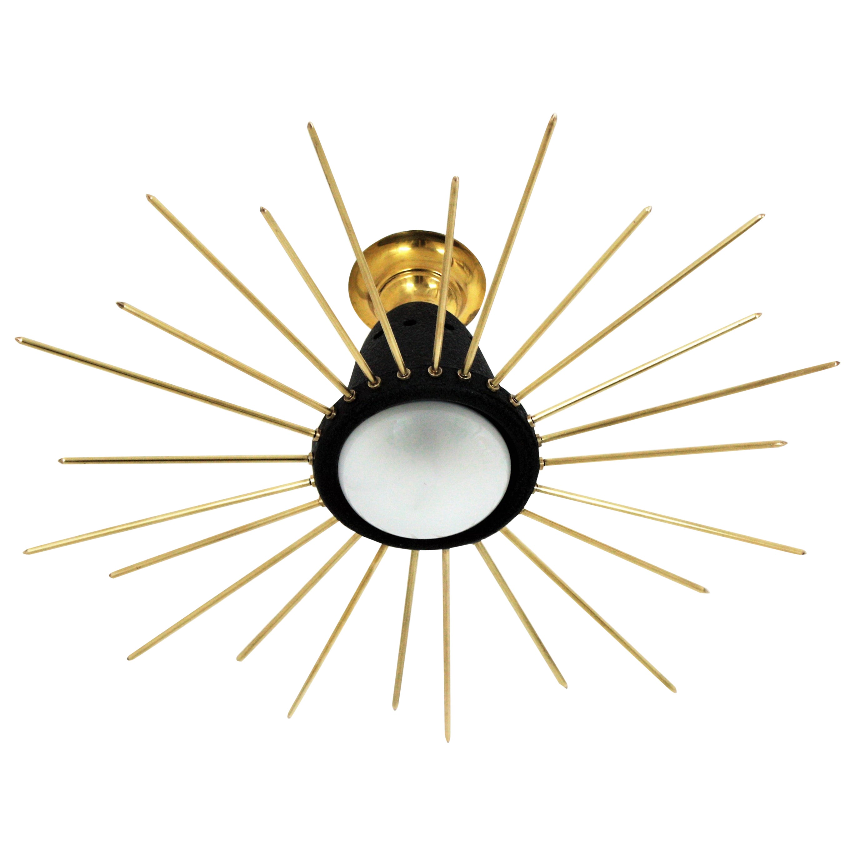 Lampada a sospensione o lampadario a raggiera in metallo laccato nero e ottone, Italia, 1950.
Questa accattivante lampada da soffitto presenta un paralume in metallo laccato nero sormontato da un baldacchino in ottone e circondato da raggi in
