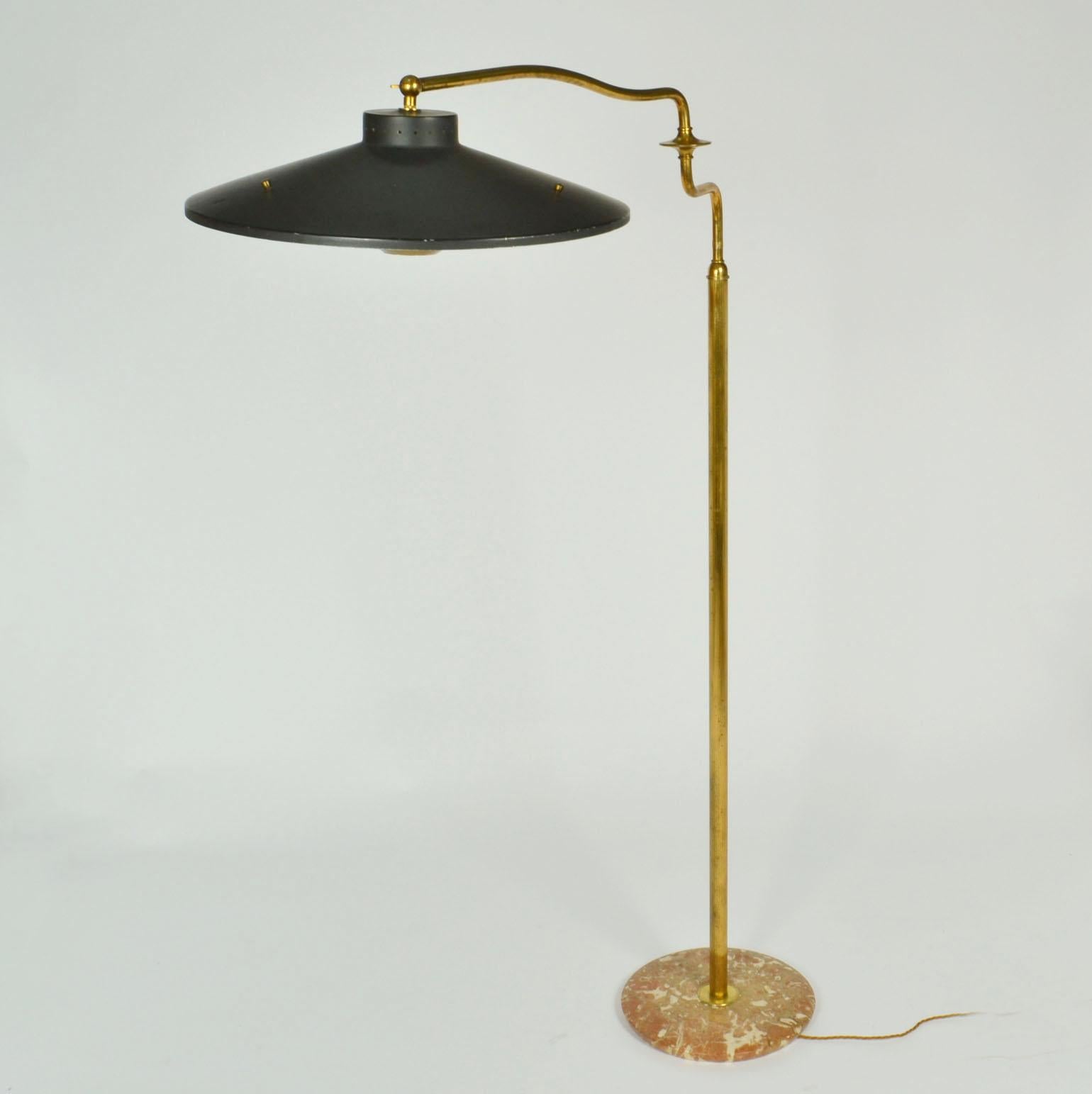 The articulated Italian swing arm brass floor lamp is multi functional added by its extending swivel arm. The original black painted cone-shaped metal tilting shade is completed with a brass diffuser held together by three black wooded arms. The