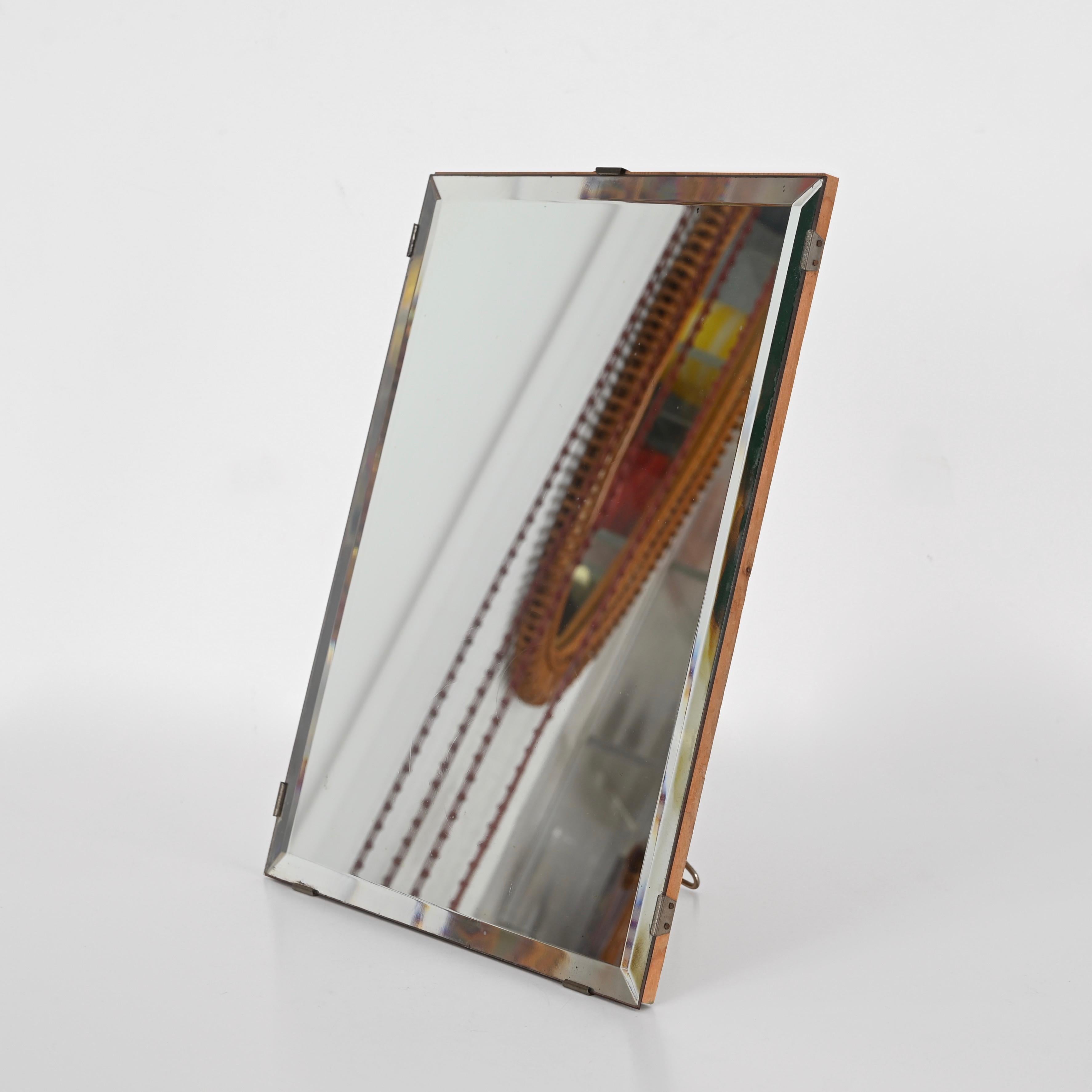 Superbe miroir de table italien à bords biseautés en bois et en fer. Cet élégant miroir a été conçu par Luigi Fontana & C. en Italie dans les années 1940.

Ce rare miroir de table rectangulaire présente de beaux bords biseautés et est monté sur une