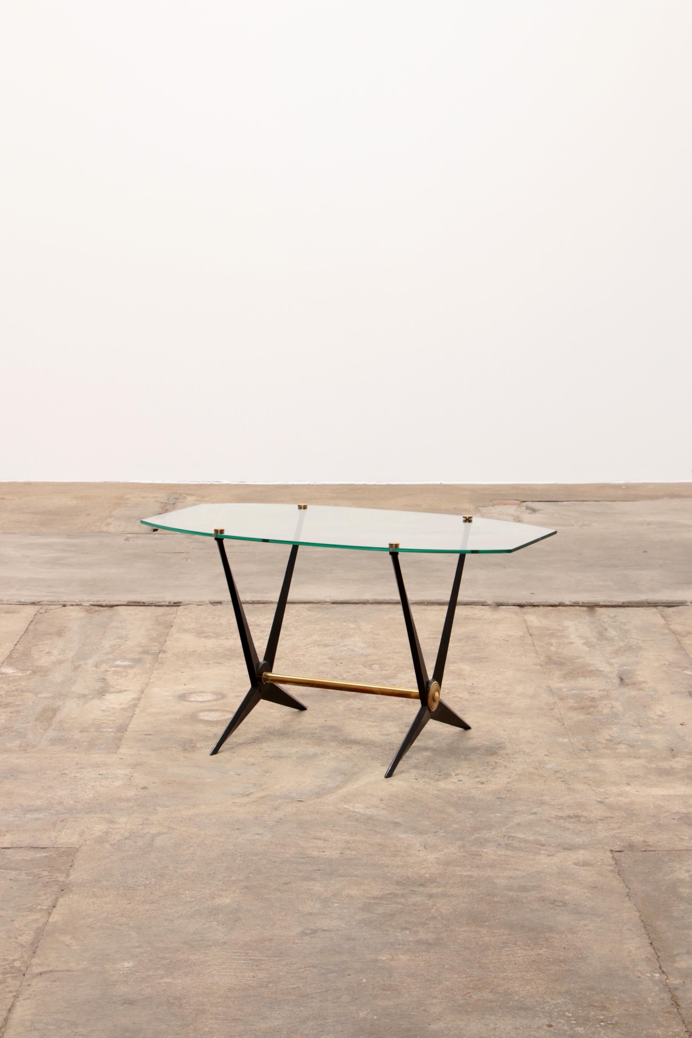 Beautiful and dynamic cocktail/sofa table designed and made by Angelo Ostuni, Italy 1950.

This table has a black lacquered metal frame and the brass details fix the glass tops between and on the base.

The table is in very good condition, there