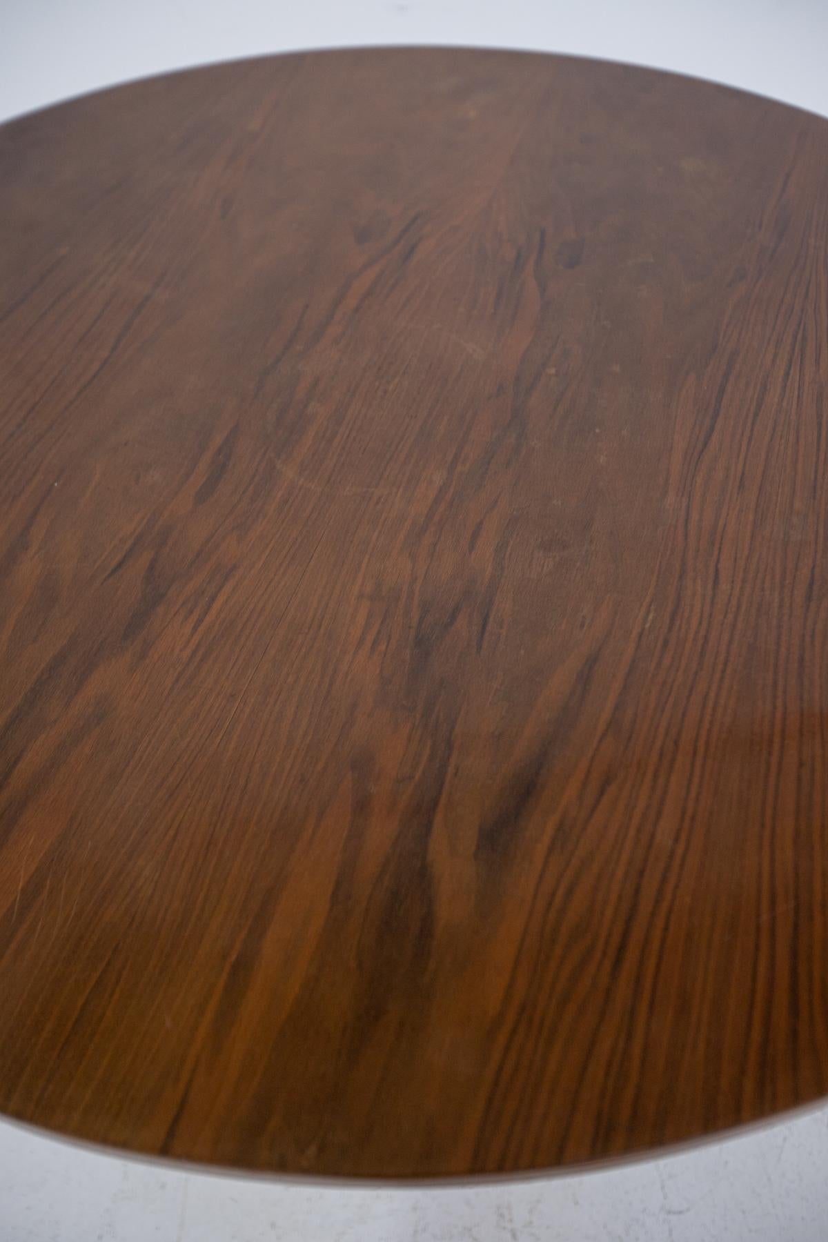 Italian table attributed to Augusto Romano. The table is made entirely of walnut wood. The table top is circular and round with wooden pedestal feet. The wood of the table top has beautiful grains, its three wooden feet have a beautiful geometric