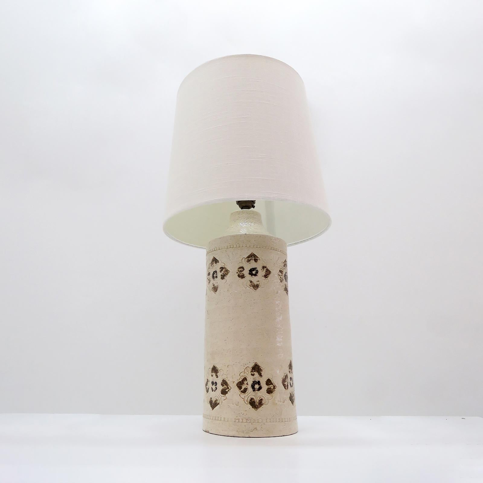 Wonderful glazed ceramic table lamp in a textured, off-white color with brown geometric decorations. marked 'Italy/Bergboms', Sweden, linen shade included, wired for US standards with on/off through switch at the socket, one E26 socket, max. wattage
