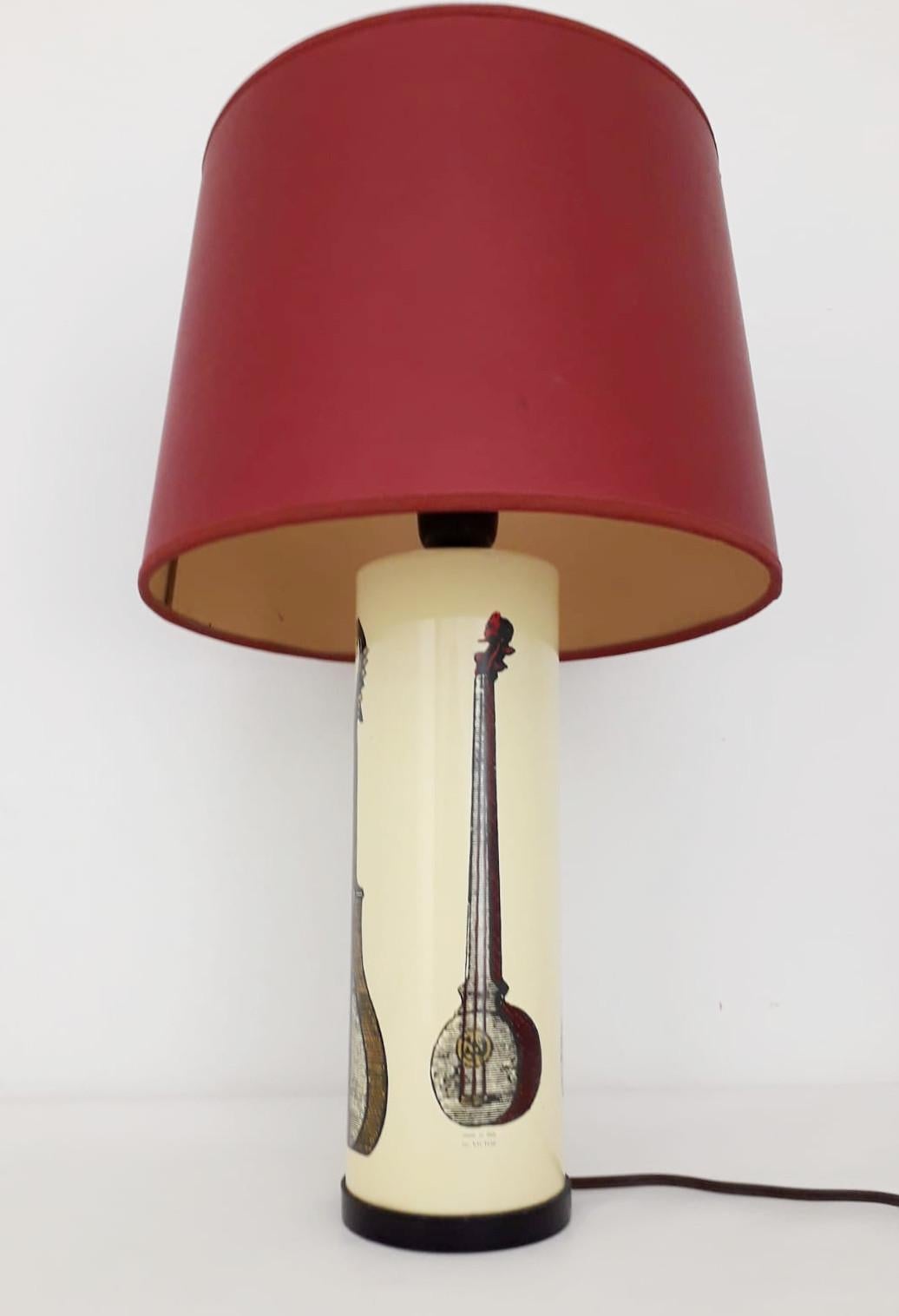 Italian vintage table lamp with painted metal lamp base decorated with musical instruments by using lithograph and transfer print, in the style of Fornasetti / Made in Italy in the 1970s
Marked 