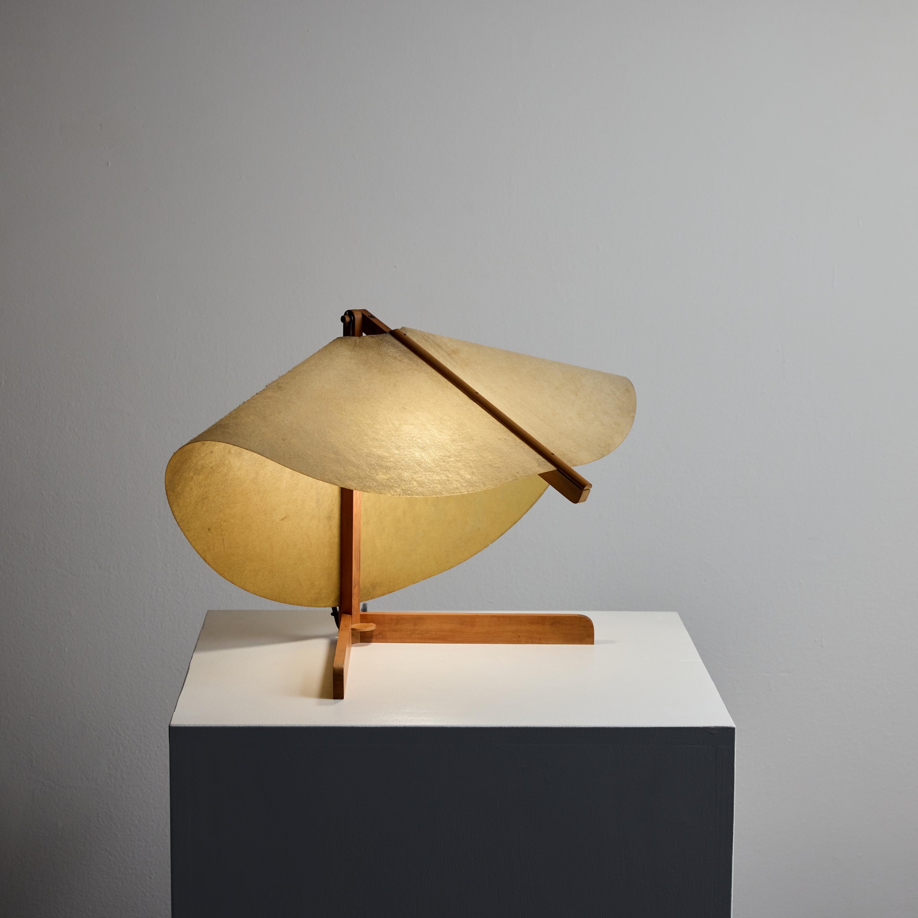 Italian Table Lamp. Designed and manufactured in Italy, circa the 1950s. Wooden table construction with a resin fiber shade. The lamp's construction allows for small vertical positioning; though the age of the parts are fairly worn and caution