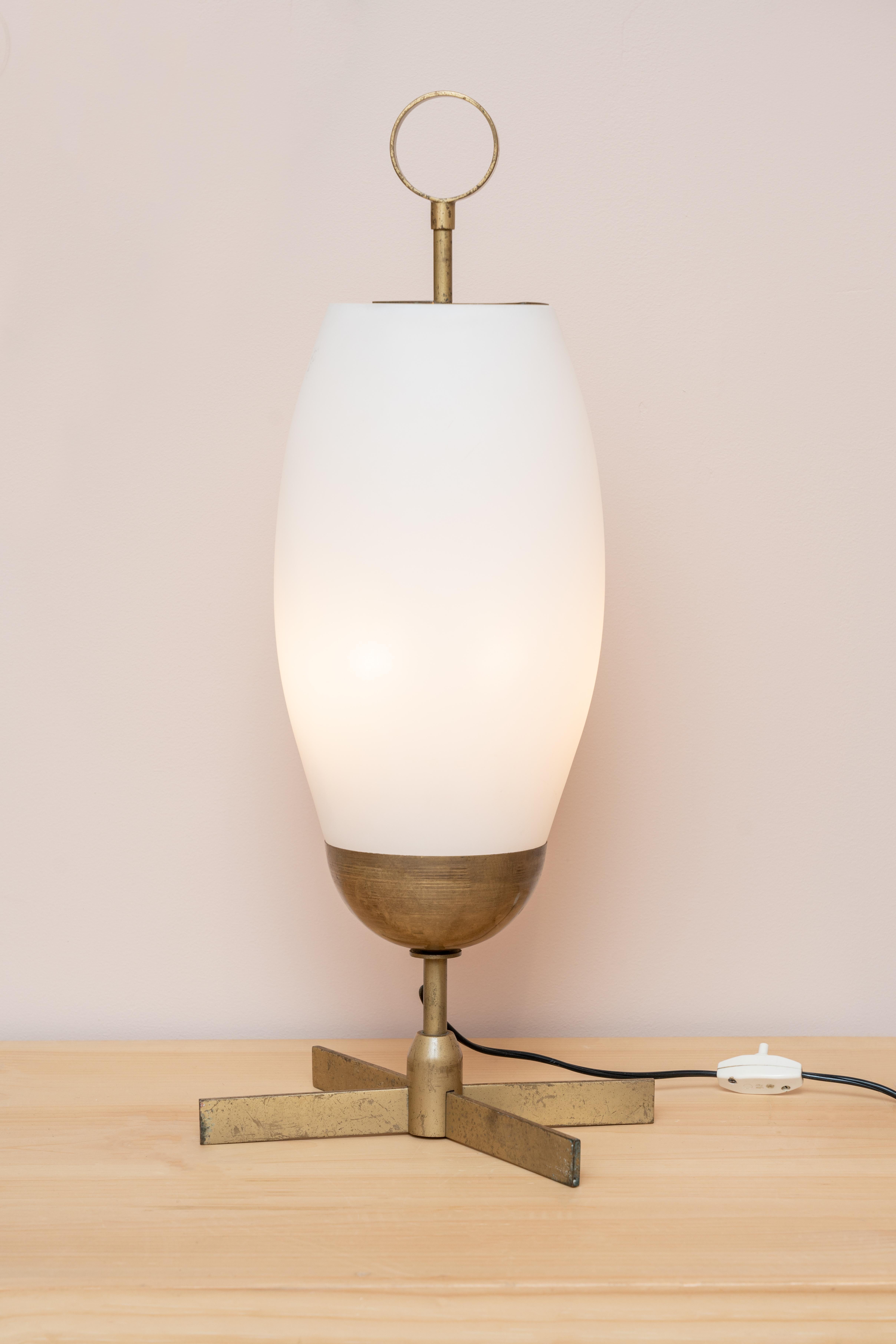 An Italian Table Lamp that effortlessly combines vintage charm and timeless elegance. Crafted in the 1950s, this lamp showcases exquisite craftsmanship with its brass construction and frosted glass shade.