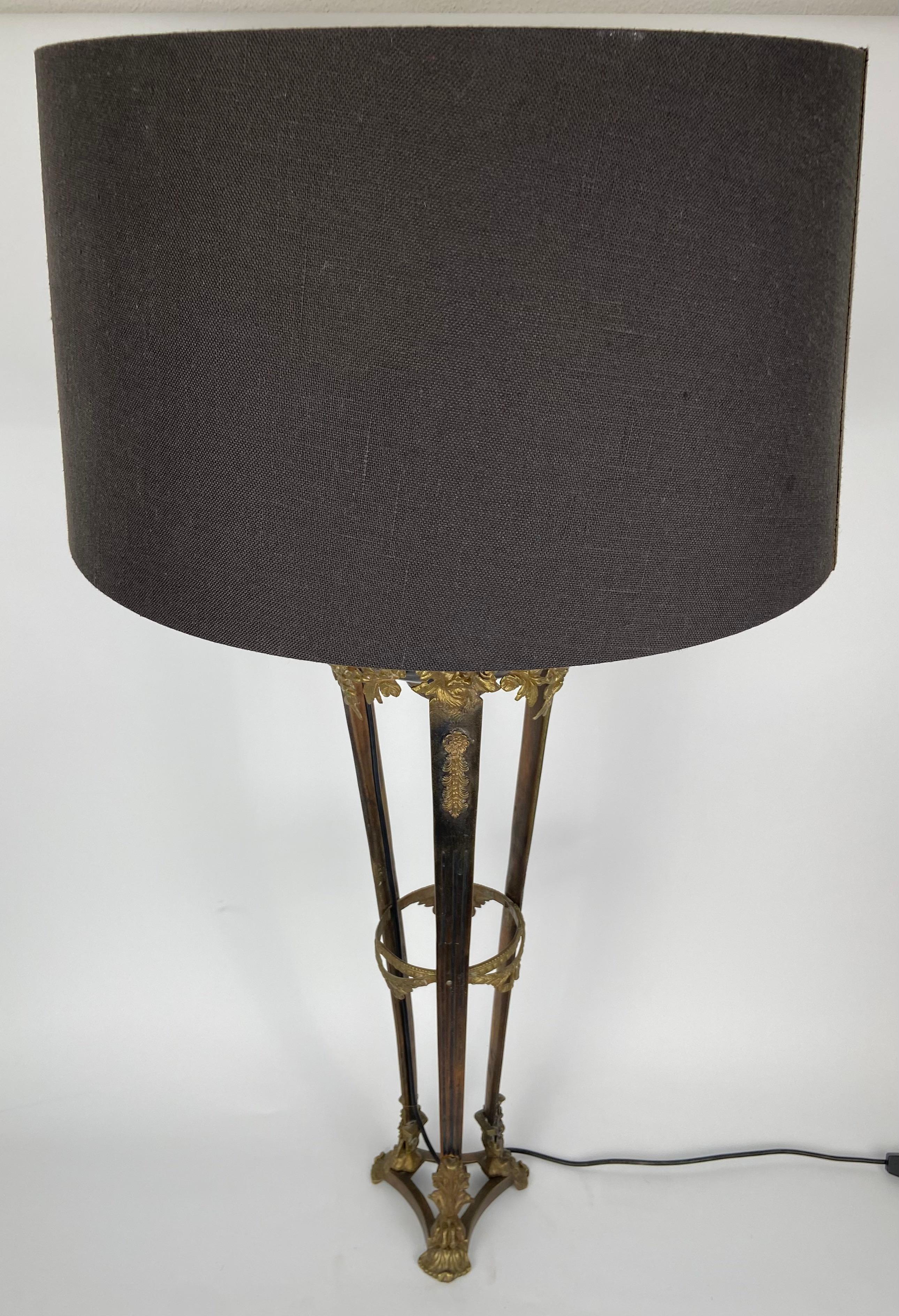 Tall Italian table lamp in bronze, decorated with masks and guirlandes.
Grey shade in linen with a gold interior.
 