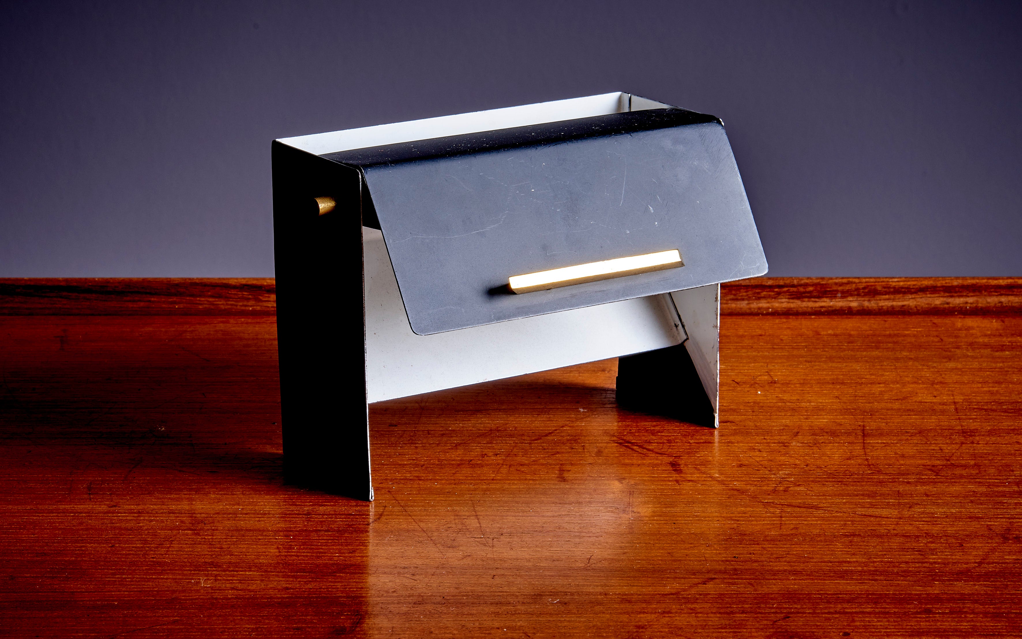 Italian table Lamp in black/white and brass with a folding metal shade to change the light.
To be on the safe side, the lamp should be checked locally by a specialist concerning local requirements.

