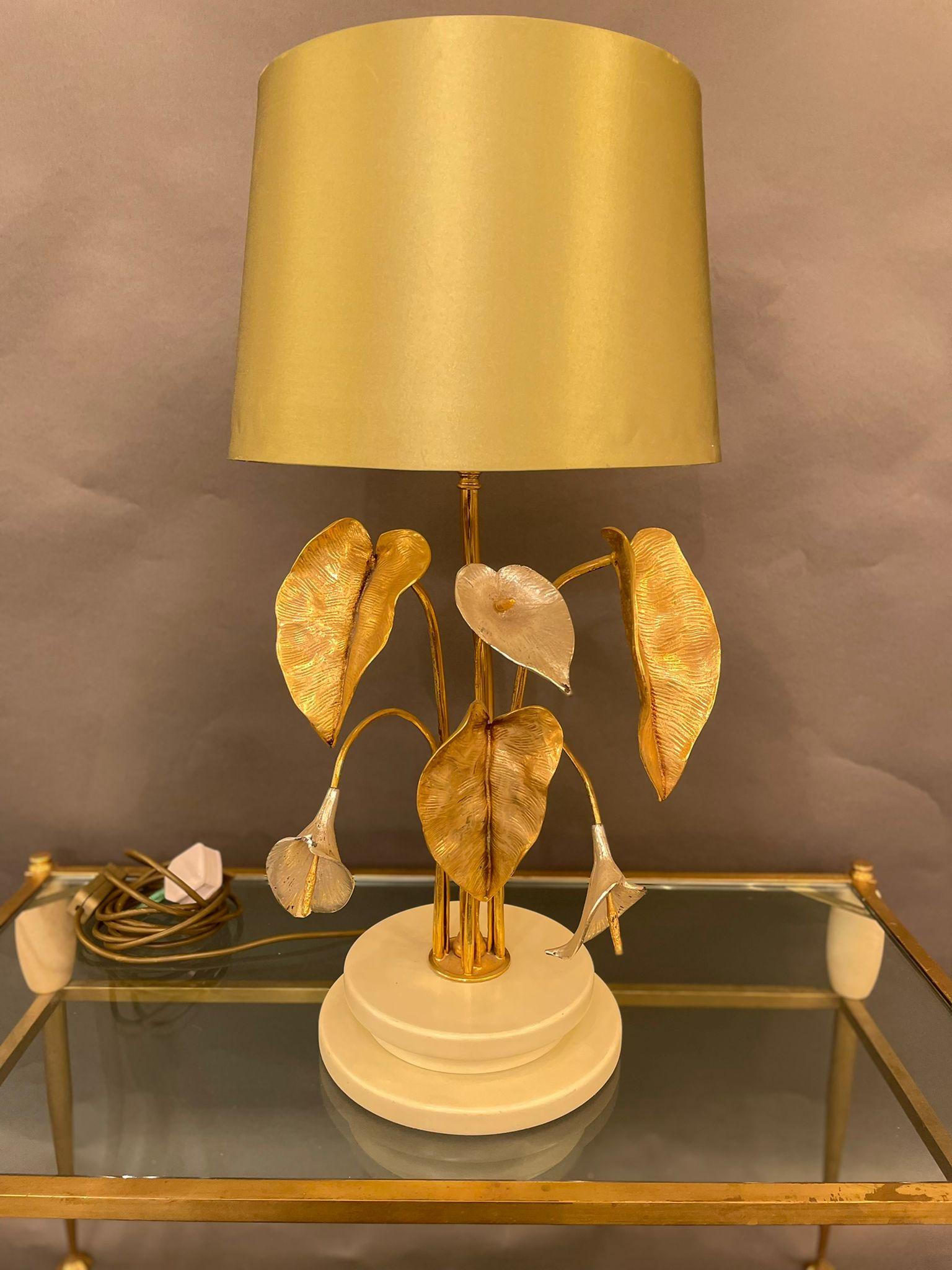 An elegant Italian table lamp in brass decorated with water lilies leaves and base in wood. Circa 1960s.