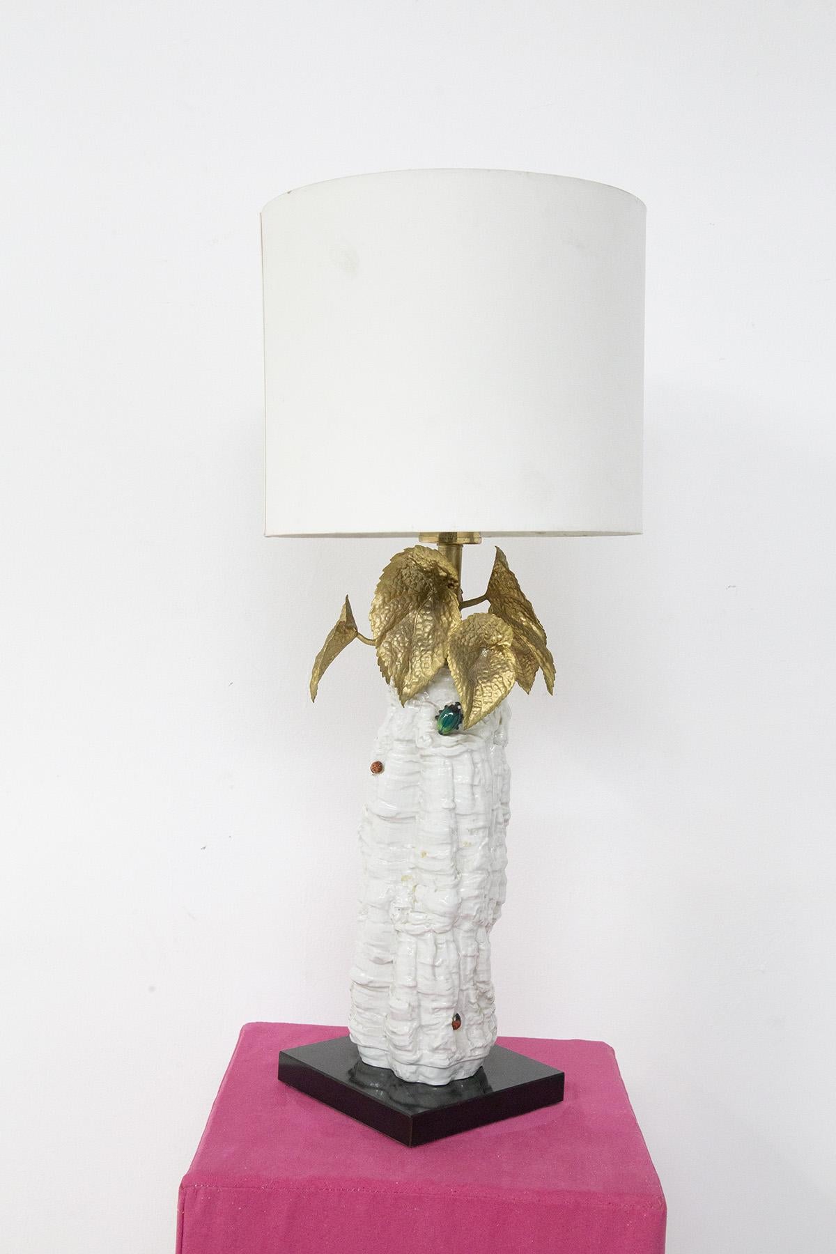 Elegant and glamorous Italian table lamp made in the 1970s. The lamp is a very glamorous and unique decorative element, made with a white ceramic body and with small, always ceramic applications of small decorative inserts . To complete the lamp we