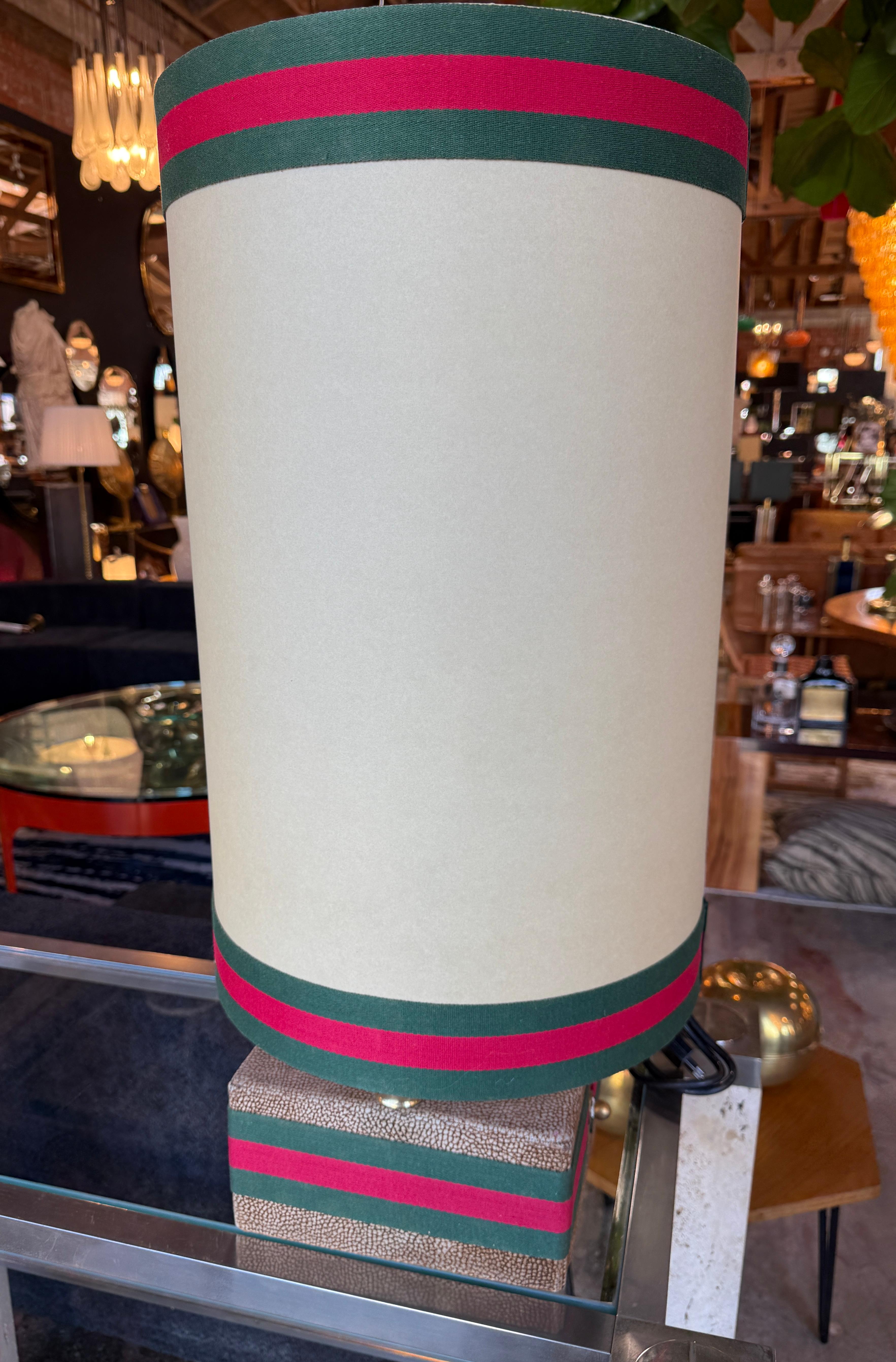 These are a pair of striking table lamps from Rossi Di Albizate's collection, designed by Carlo Bartoli known for their innovative and artistic lighting designs. The lamps feature cylindrical cream-colored shades with a bold design element: green