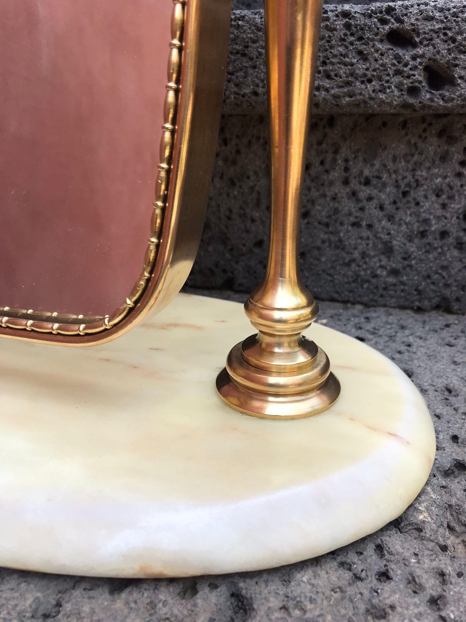 Specchio da tavolo di design italiano in ottone massiccio montato su una base in marmo di Carrara. In ottime condizioni vintage

Dimensioni dello specchio cm:25,5L x 36H
