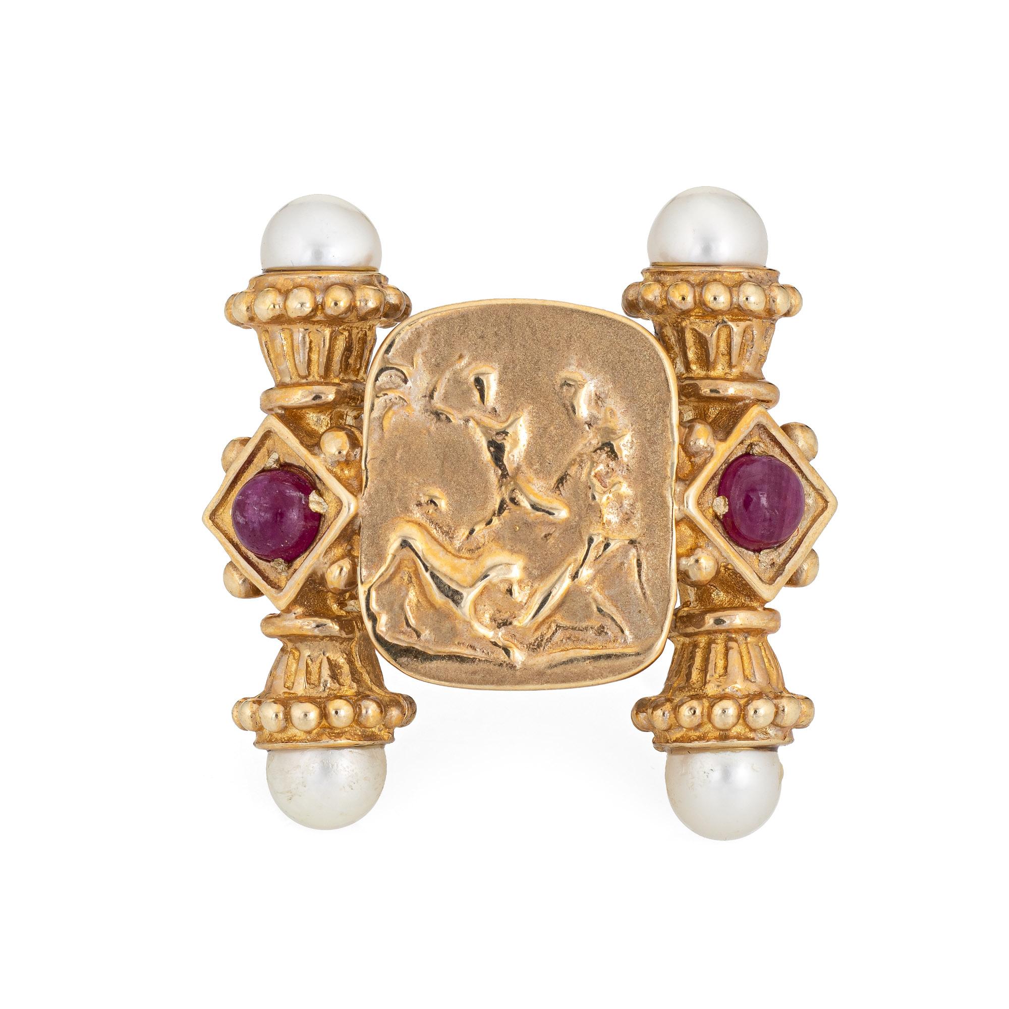 Stylish Italian Tagliamonte ring crafted in 14 karat yellow gold. 

Cabochon cut rubies are estimated at 0.20 carats each and total an estimated 0.40 carats. Four pearls measure 5.5mm each. 

The cameo style ring depicts an artful scene framed with